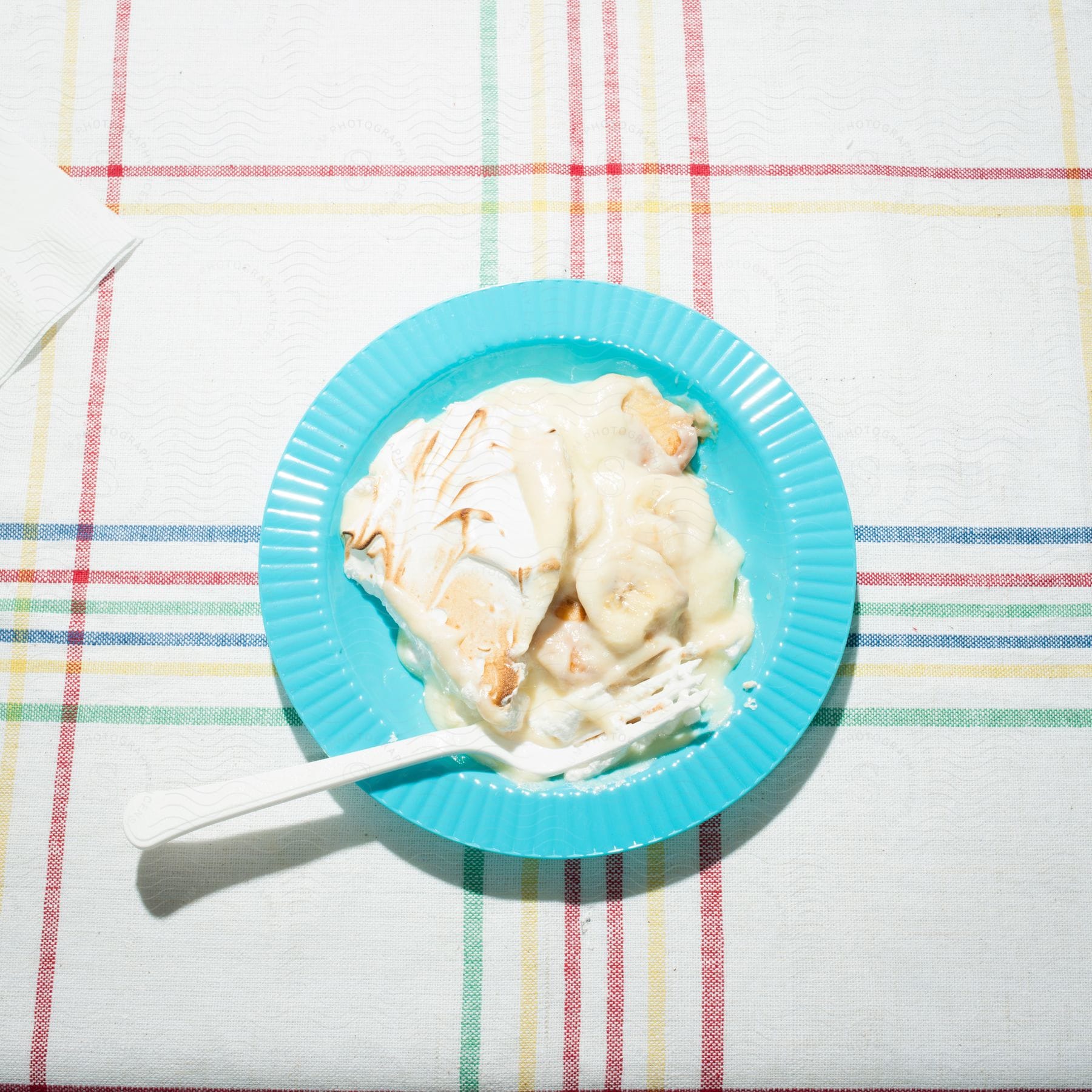 A neutral dessert with cream and a fork on a plate