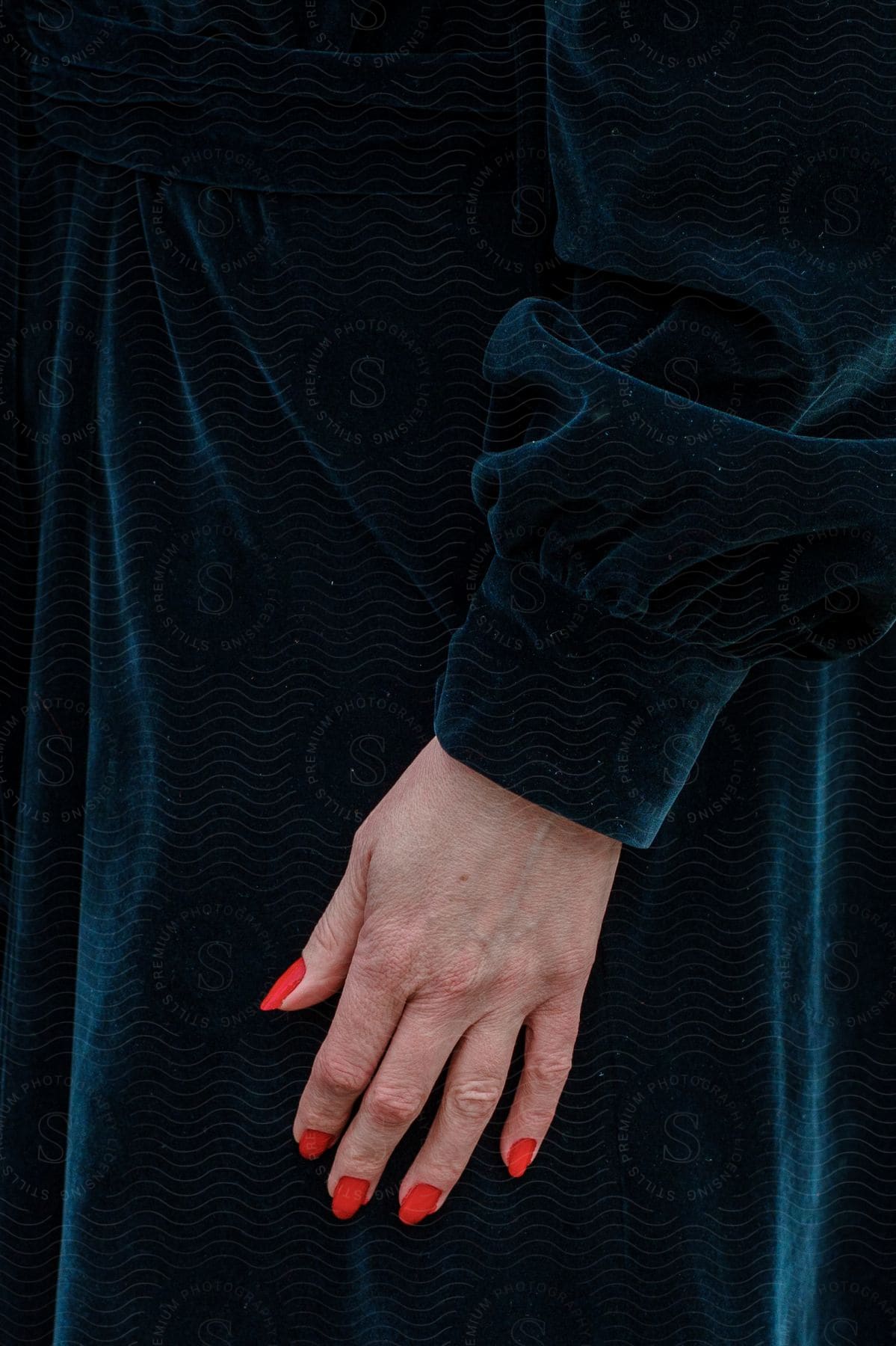 Photograph of a hand with red painted nails