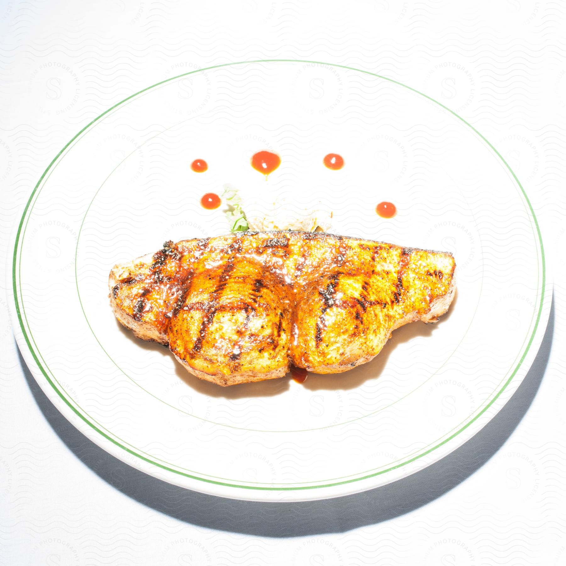 Grilled chicken breast served on a white plate