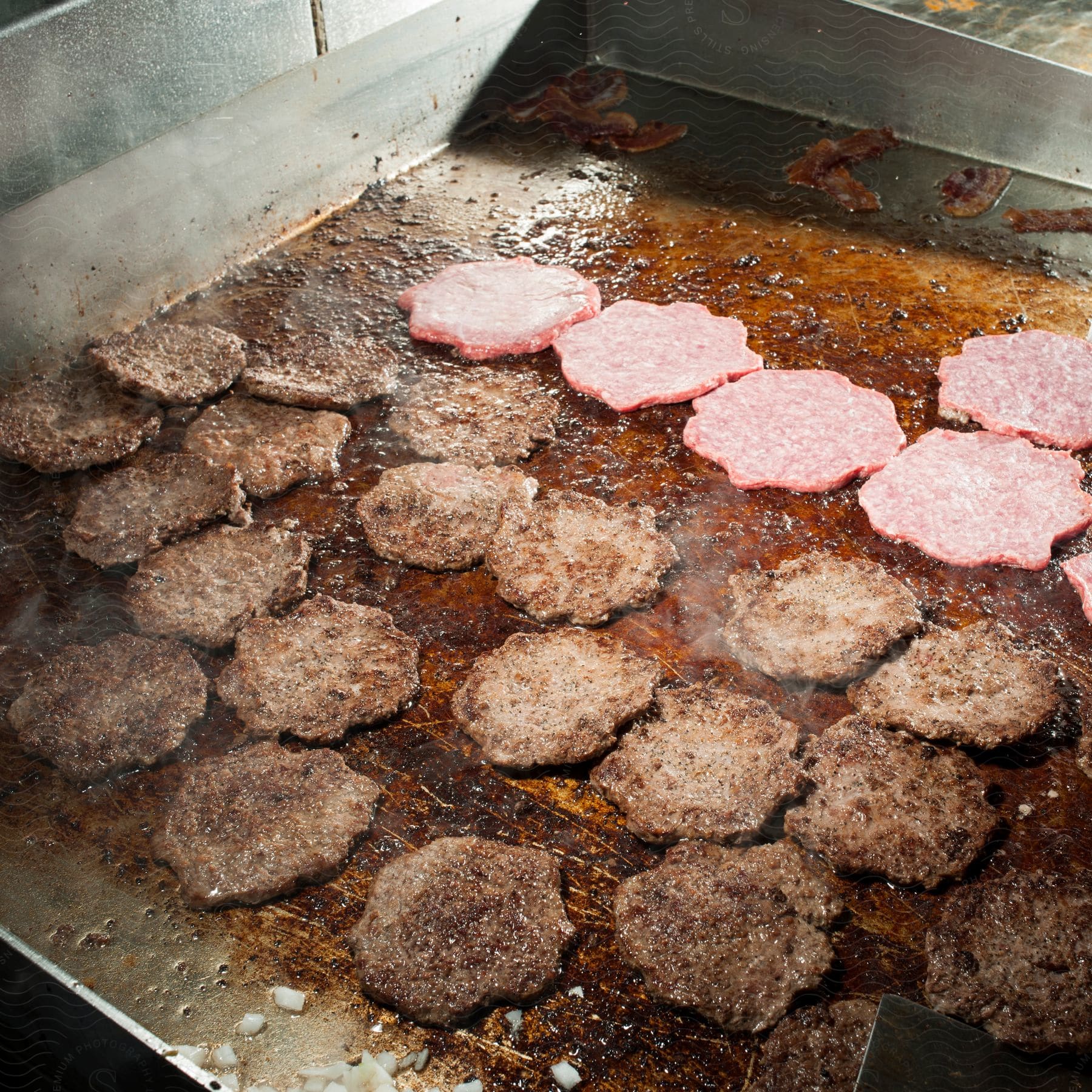 Burgers cooking on a commercial grill