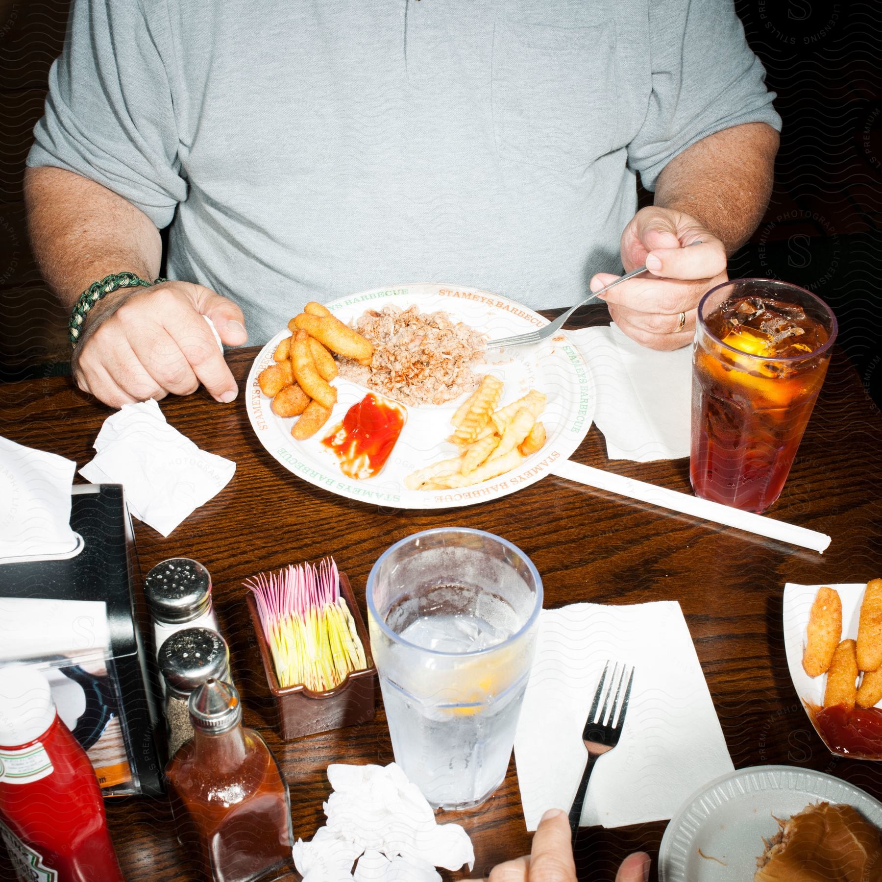 A man eating at a table with a beverage