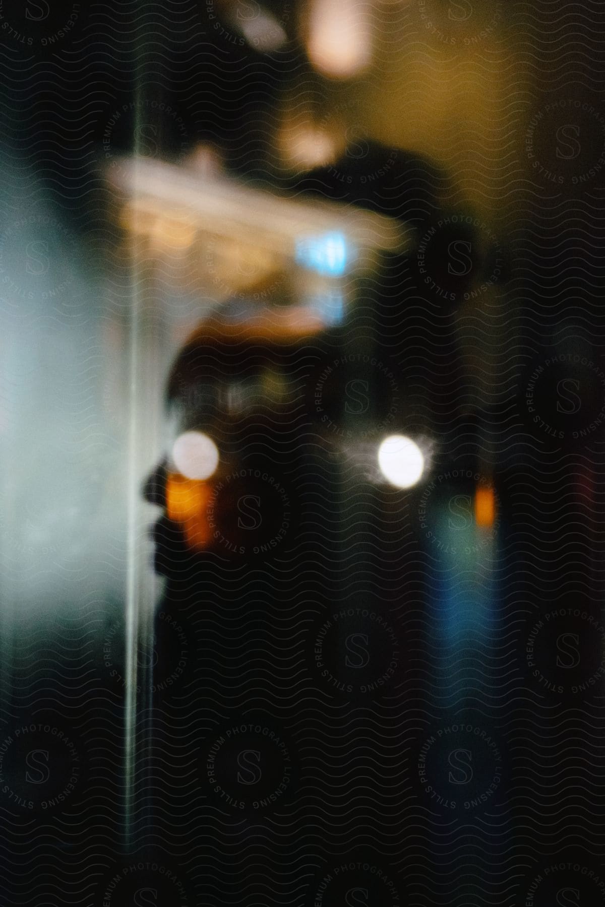 A womans silhouette from hair bun to waist against a background of blurry lights and random circular lights