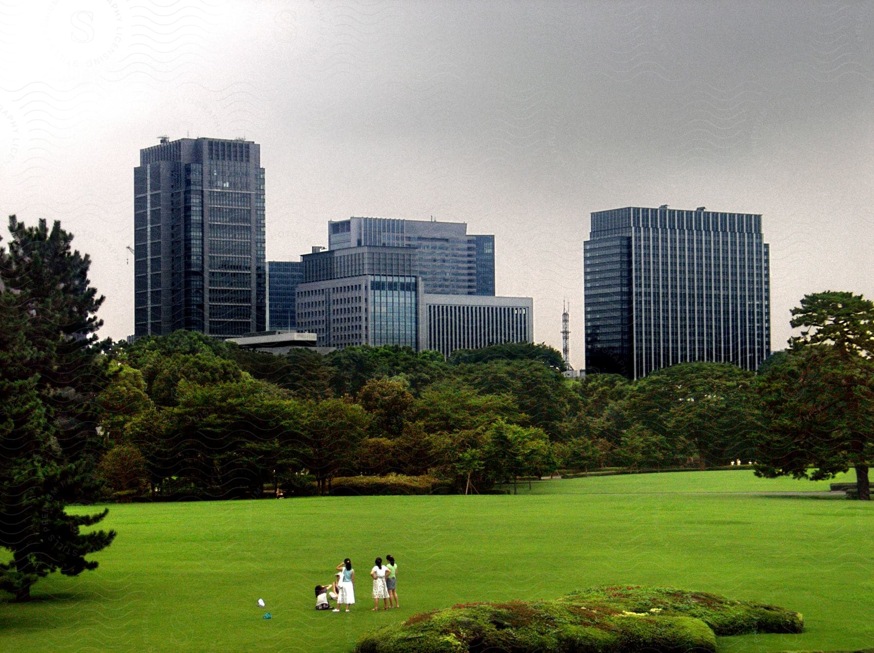 People enjoying a downtown park surrounded by skyscrapers