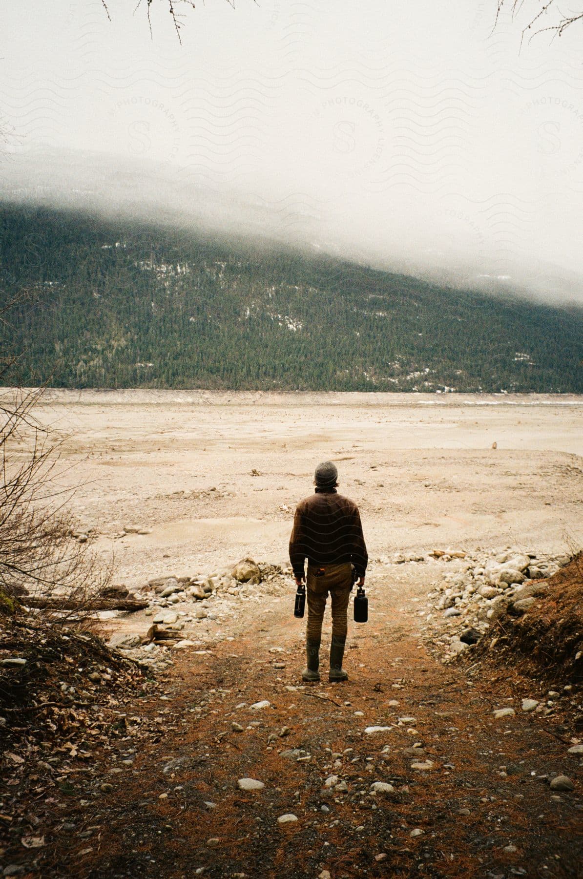 A man standing on a gravel path in the canadian rockies