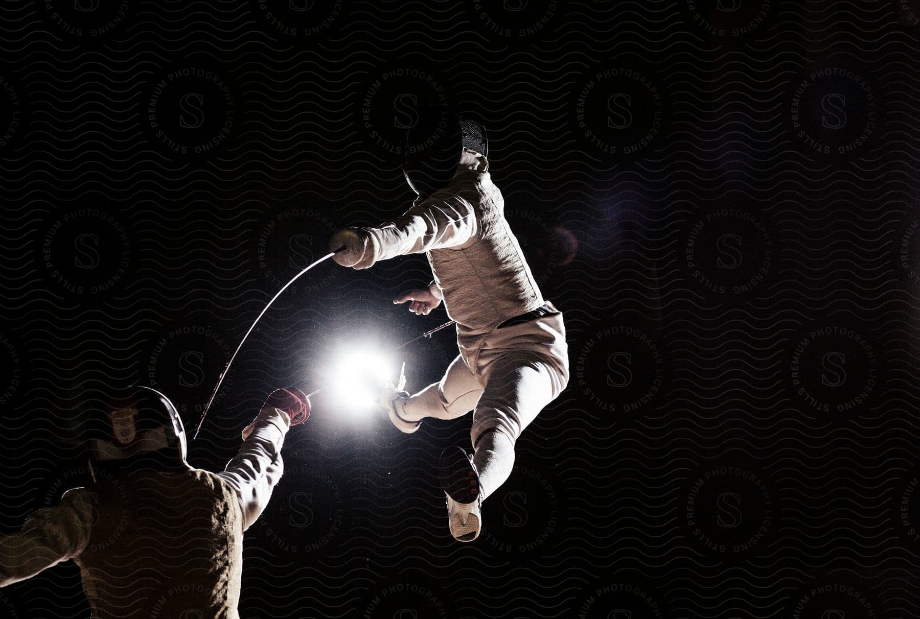 Stock photo of two people engage in combat at night wearing masks