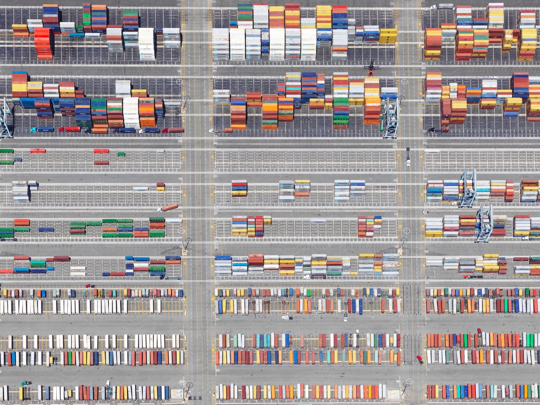 Aerial view of shipping containers of various colors sorted by size on a container terminal