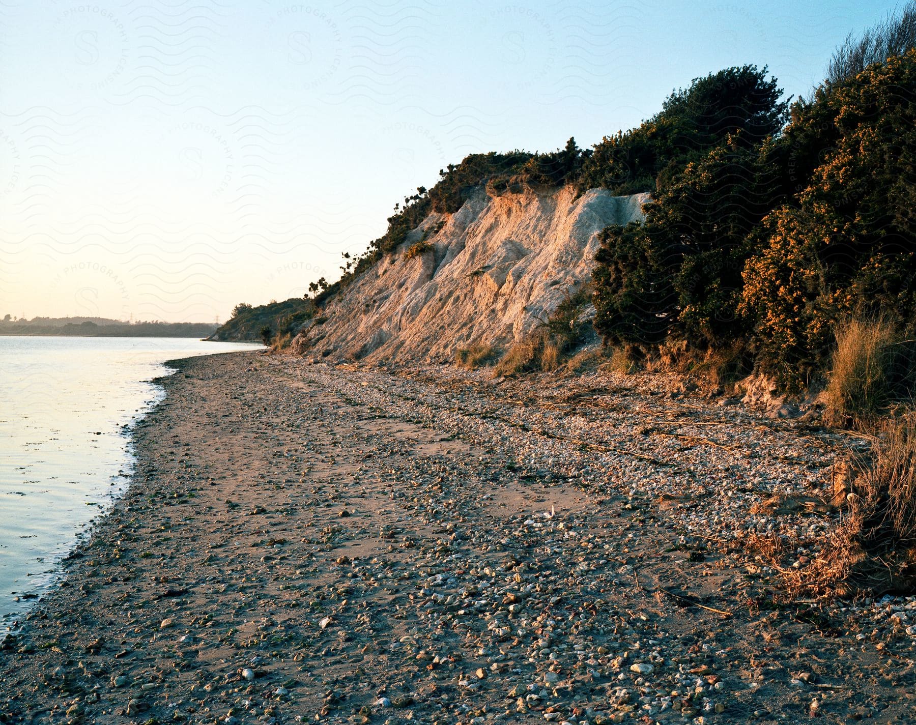 A serene coastal landscape with a rocky shoreline and a sandy beach
