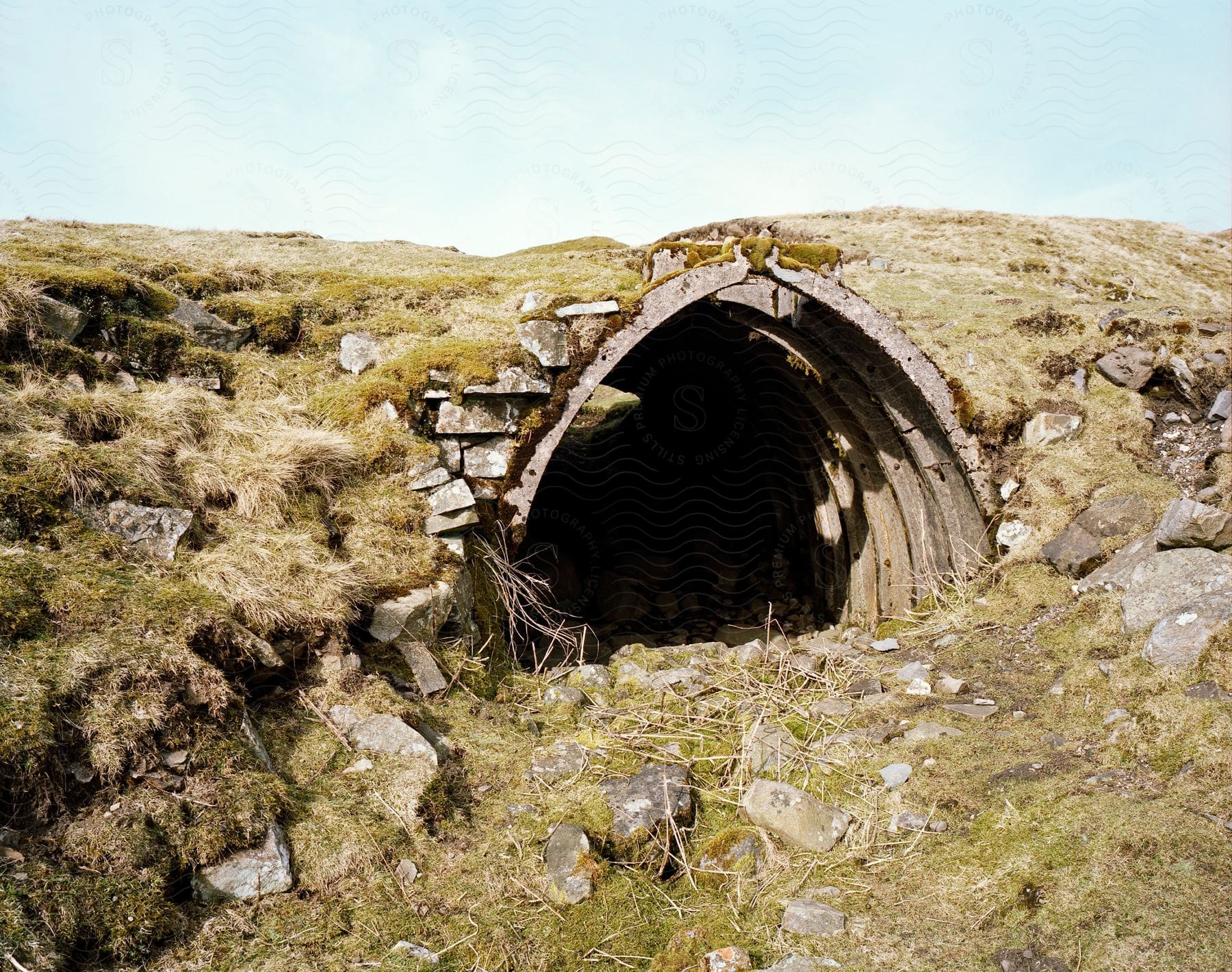 A sewer tunnel entrance is seen in a field