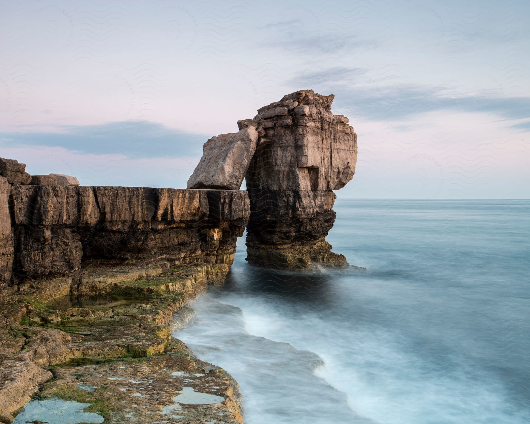 An aerial perspective of a rock formation on a beach coast