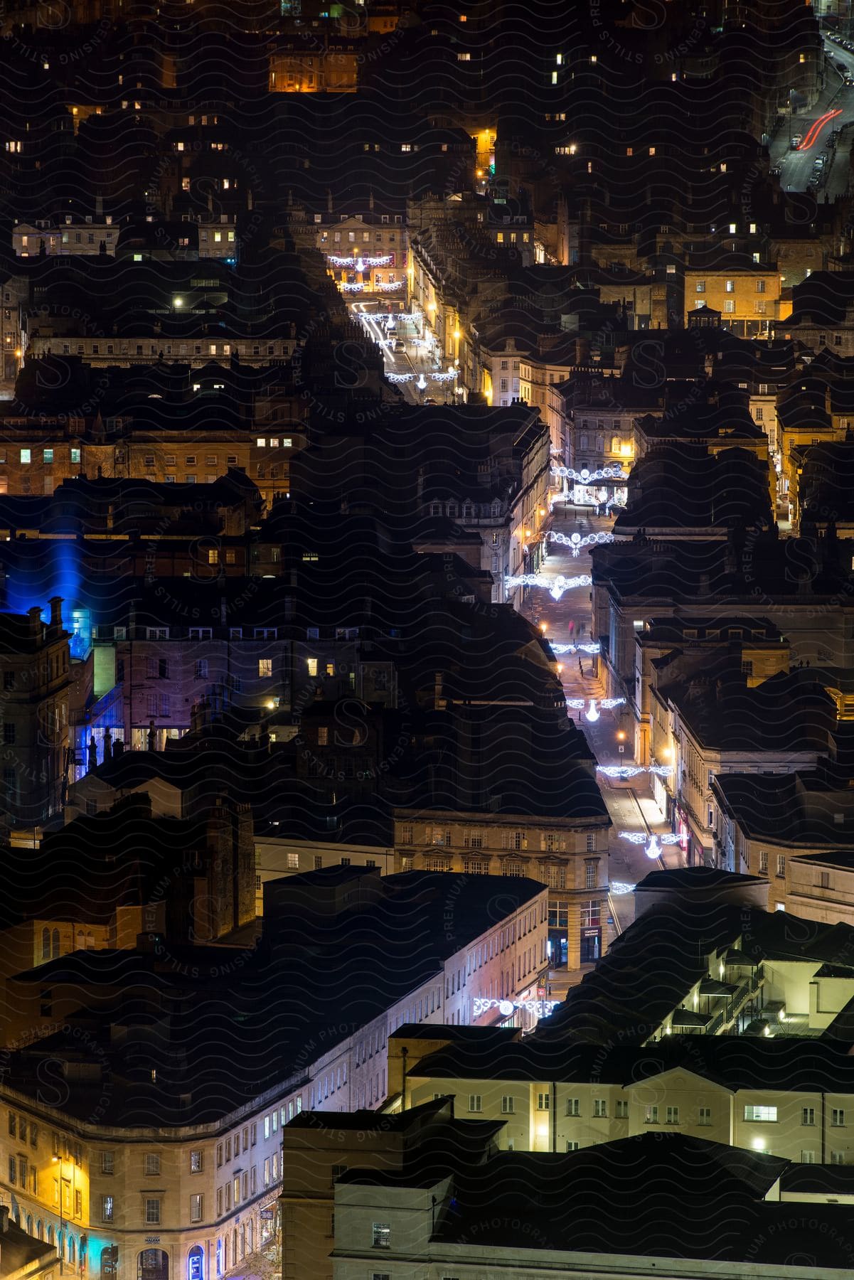 A brightly lit street runs through a european city at night