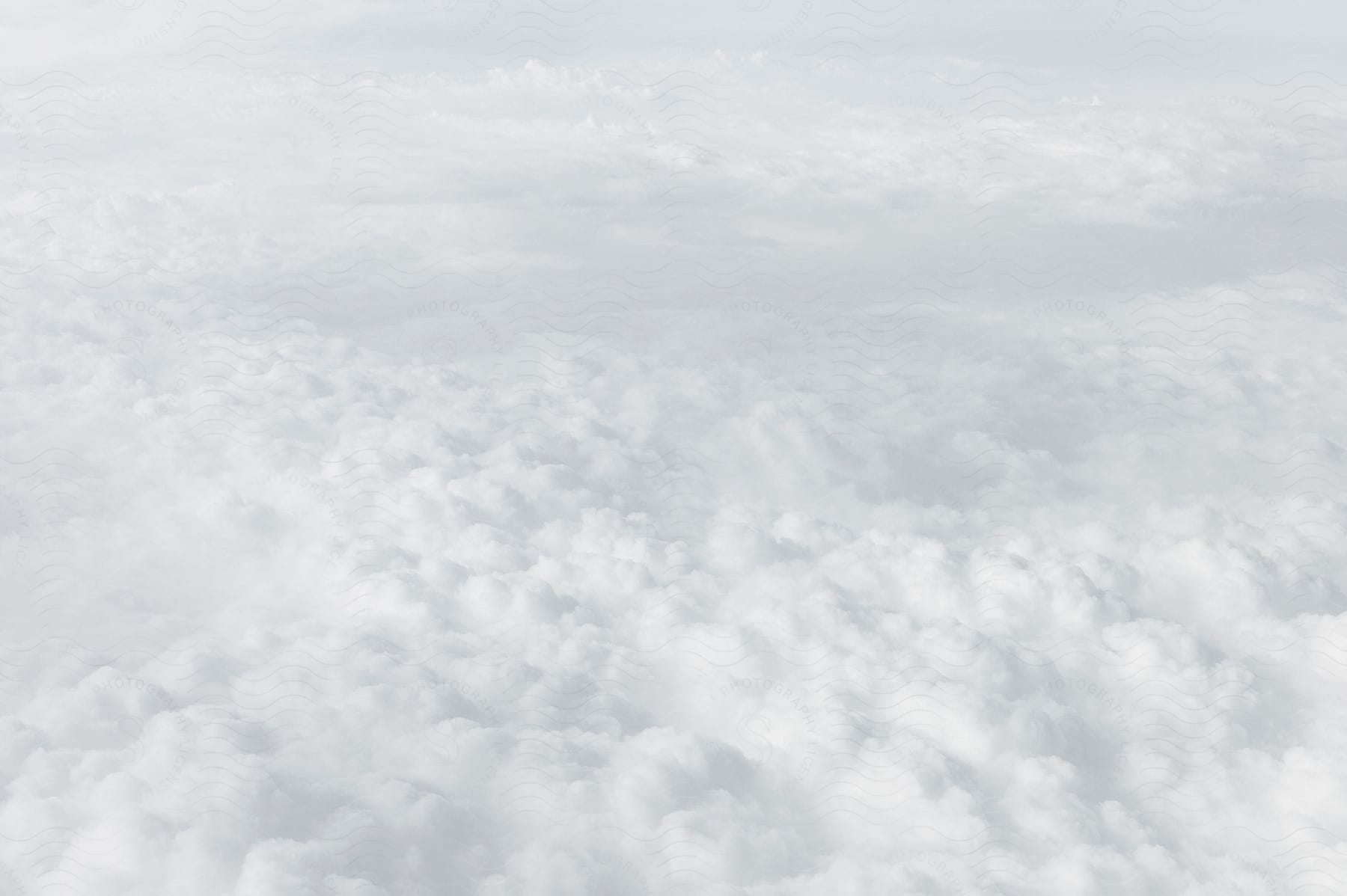 Above white fluffy clouds in a hazy sky