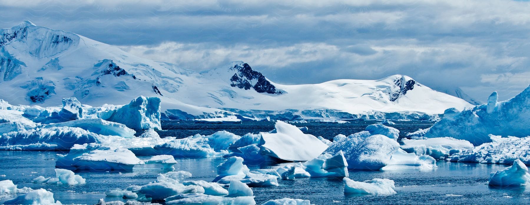 Icebergs are seen on the coast of an arctic mountain range