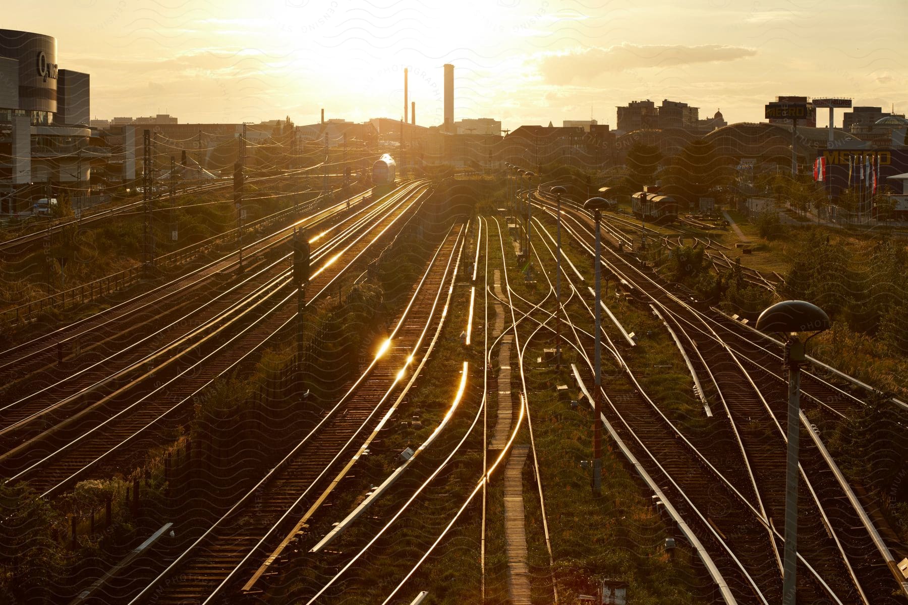 A train yard in a citys suburbs in the evening with the sun setting