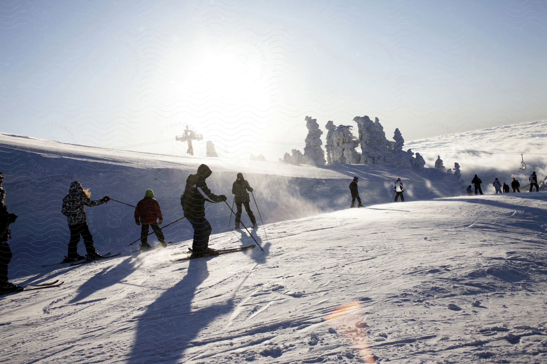 People skiing on snow in a high mountain above the clouds on a sunny day