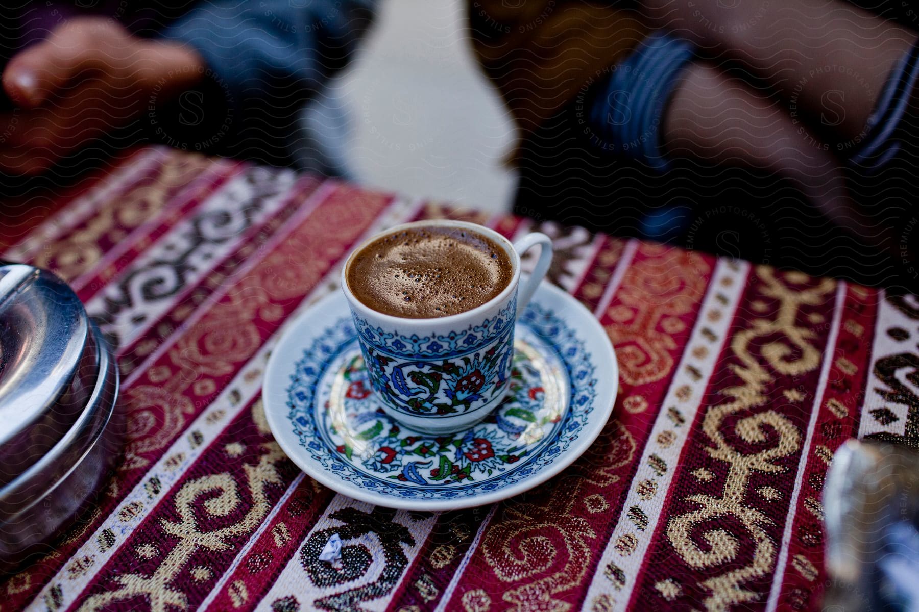 Close up of turkish coffee on an ornate cup over a small table