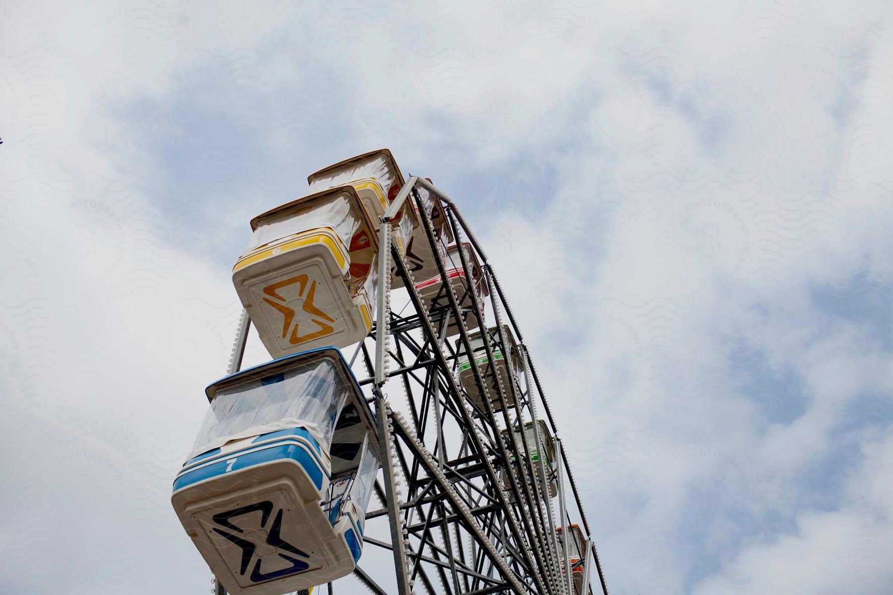 A ferris wheel is seen against a cloudy sky