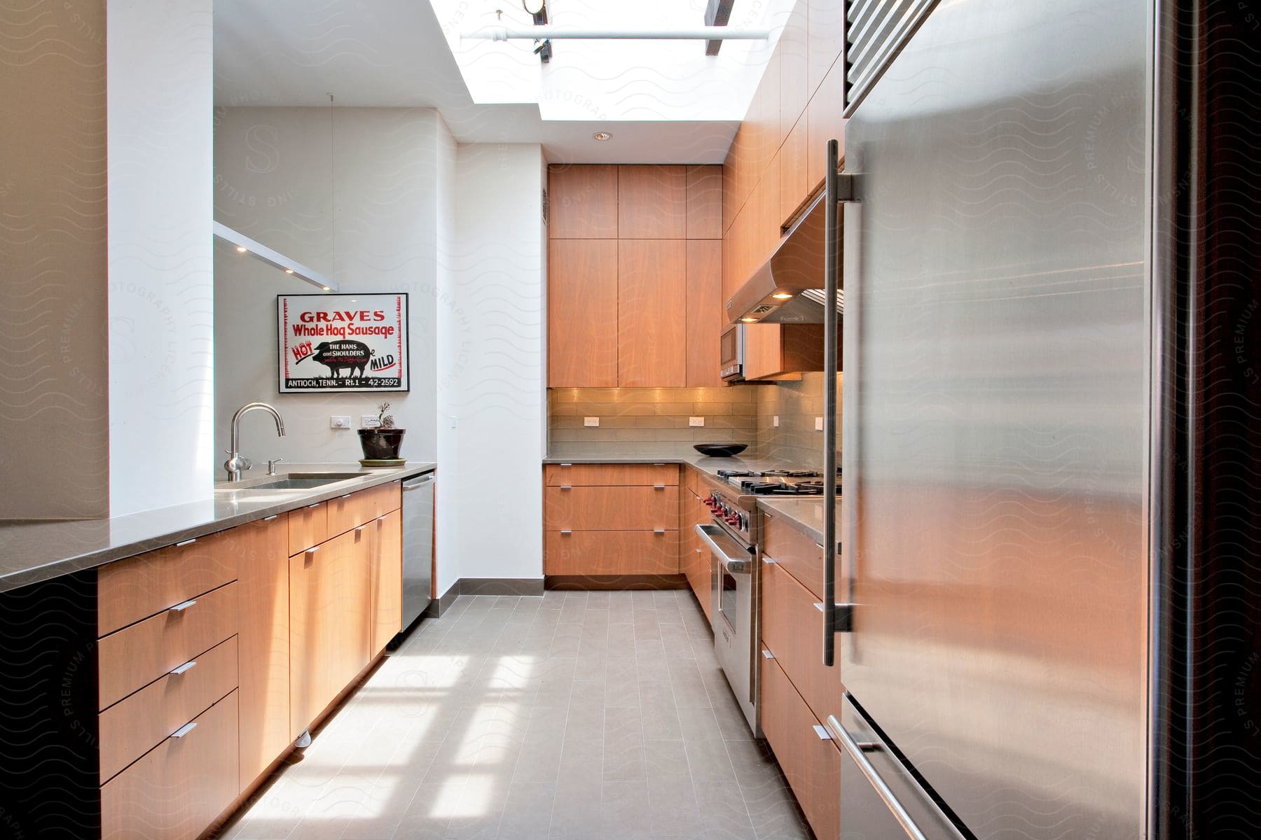 A welllit modern kitchen with stainless steel appliances and a skylight