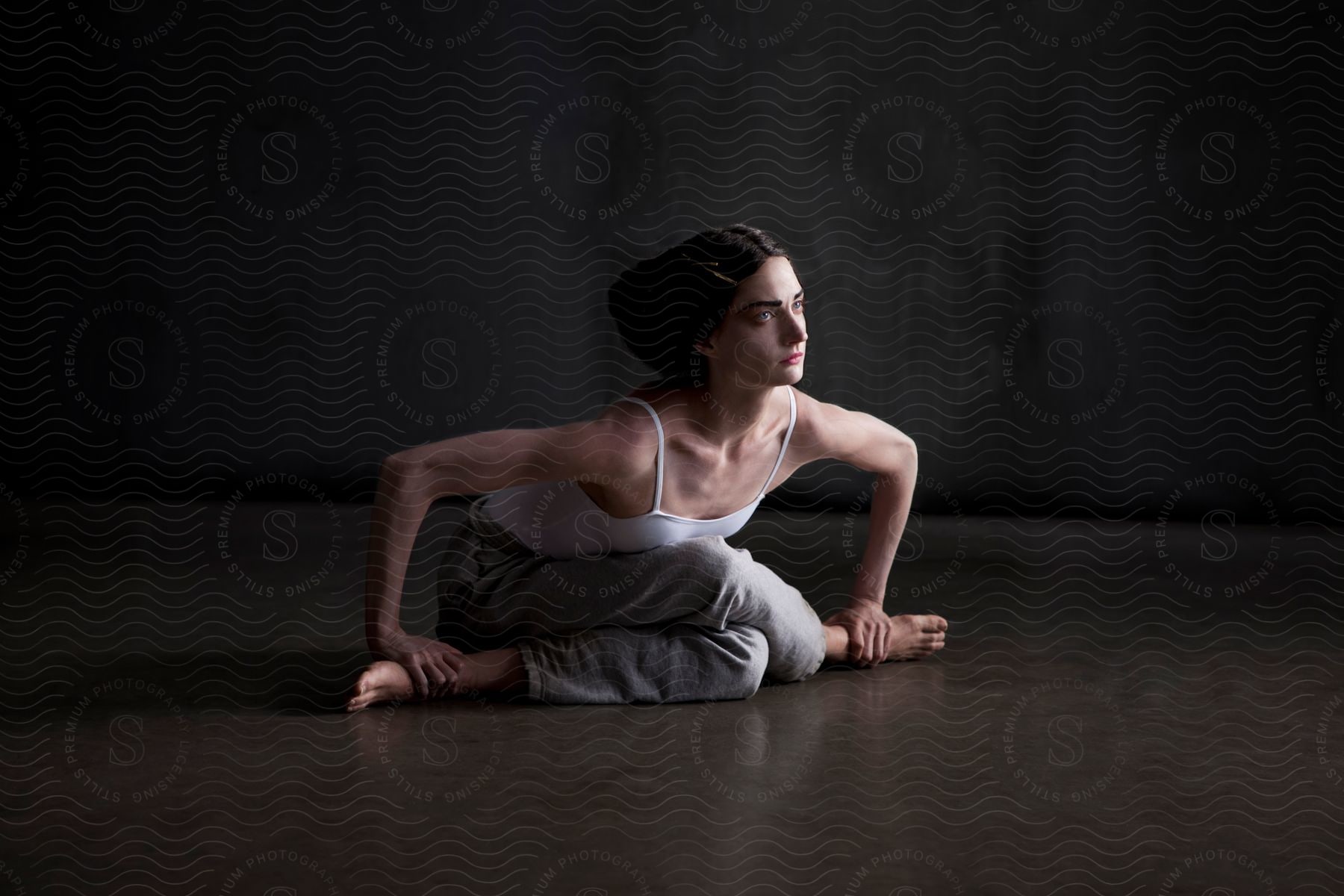 A woman dancer bending down with crossed legs