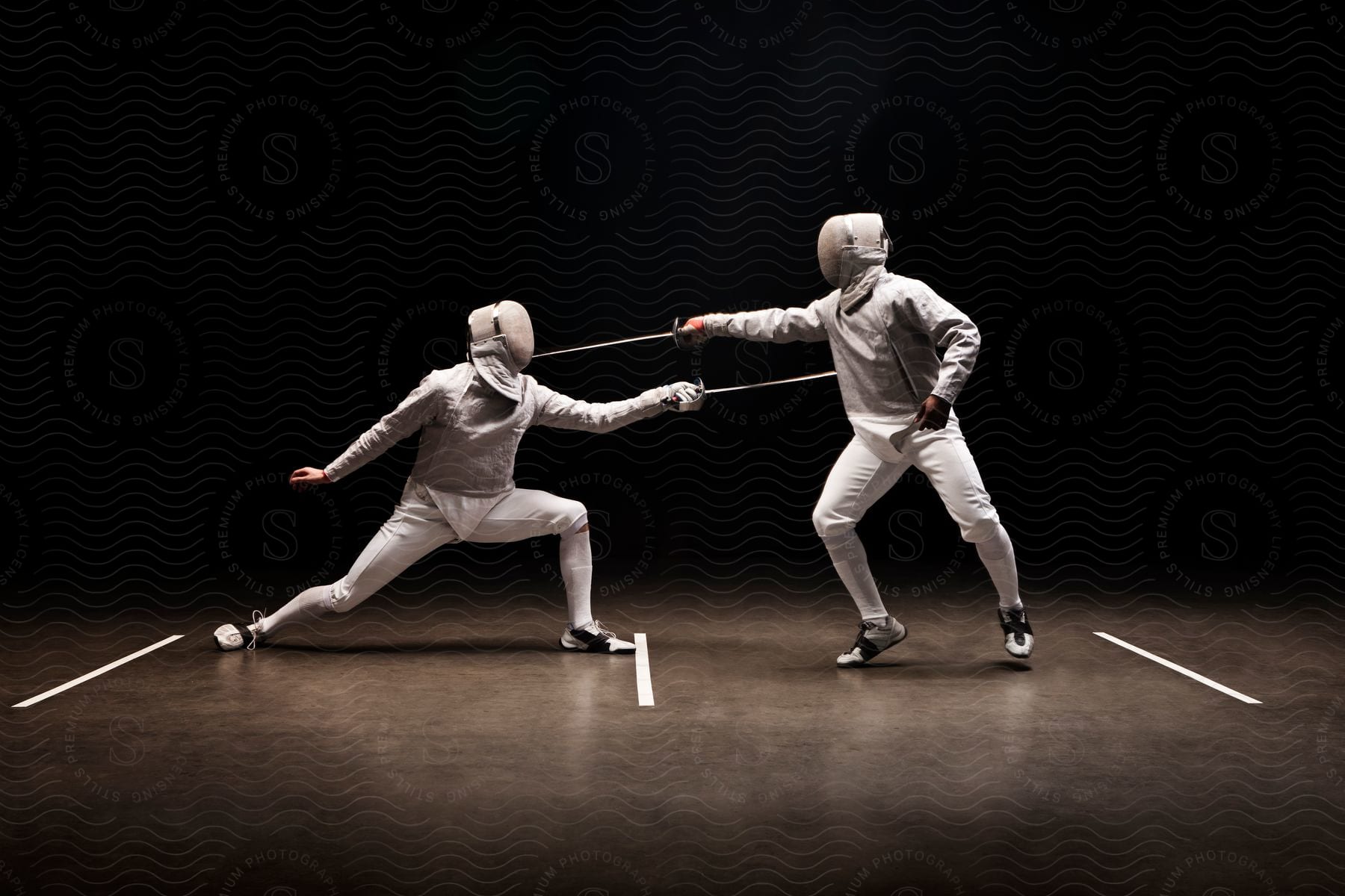 Two men engaged in a fencing match wearing protective equipment and holding fencing foils