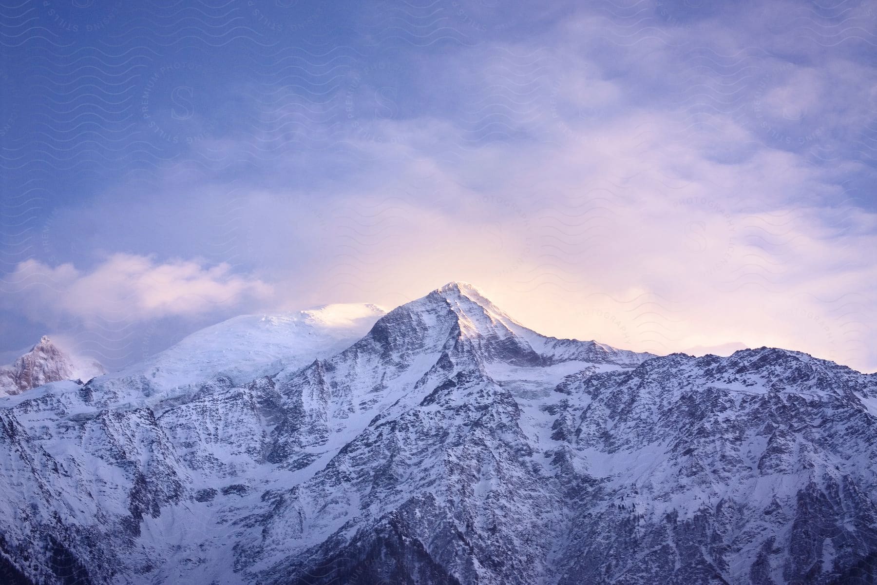 A snowy mountain peak under a cloudy sky