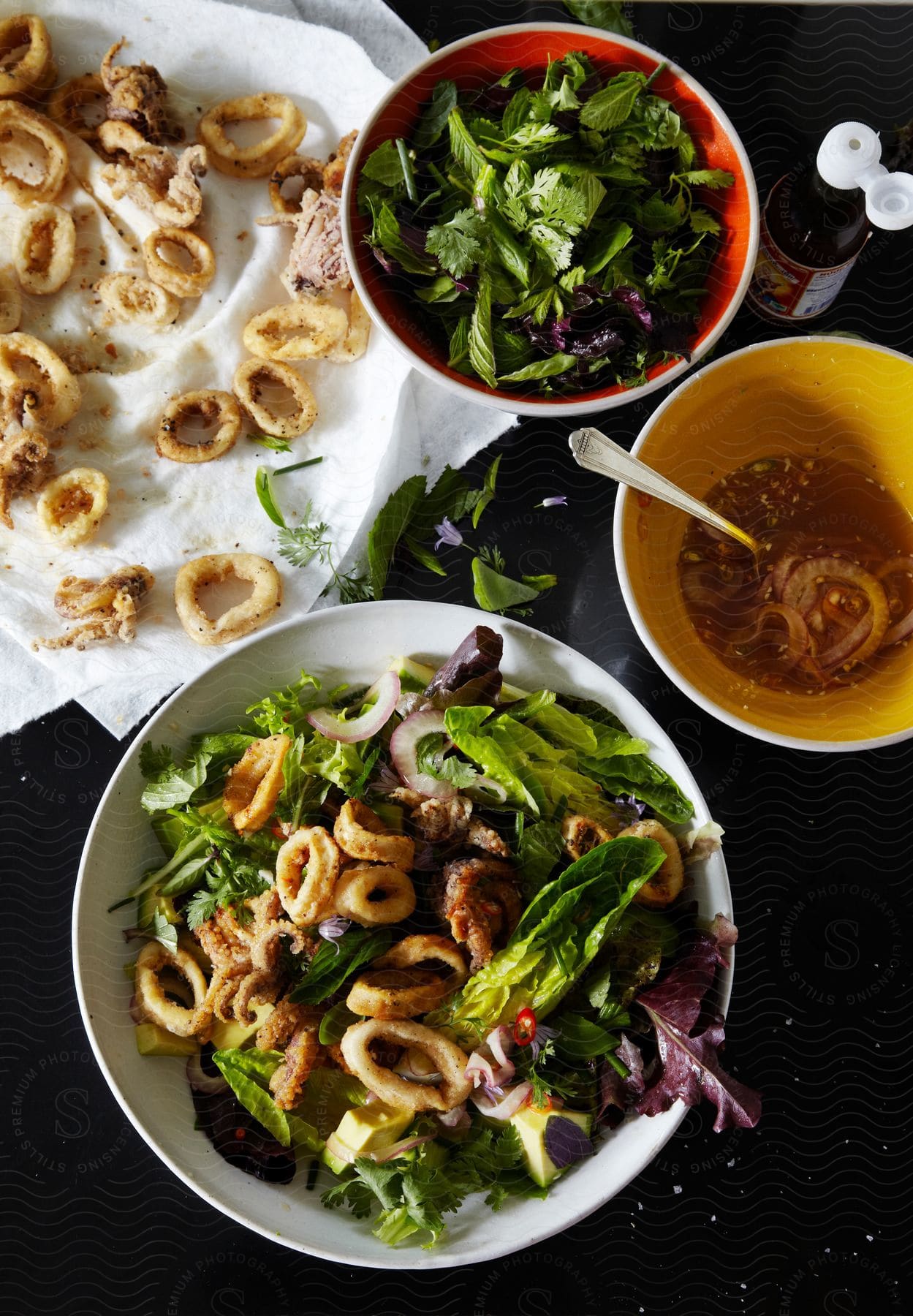 A plate of fried calamari served over salad