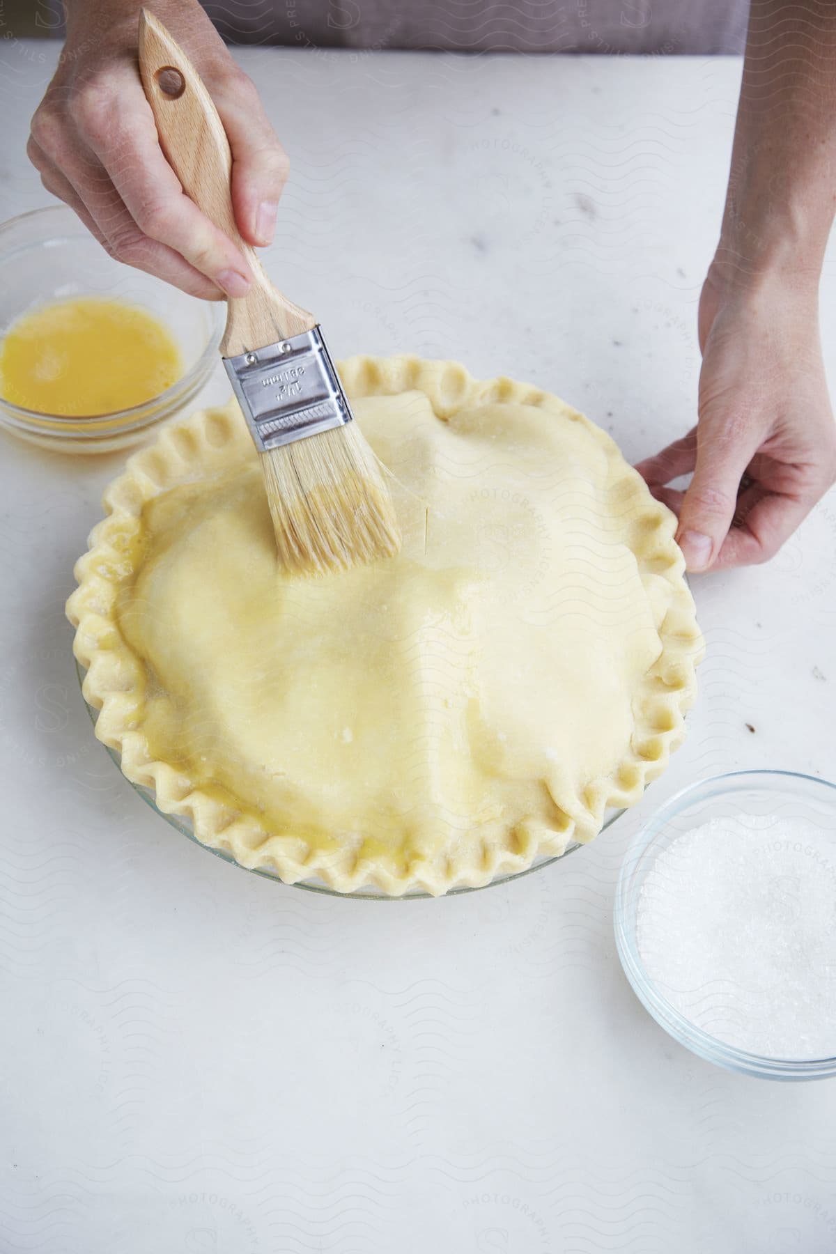 A plate with a flour dough and a brush rubbing a substance on it