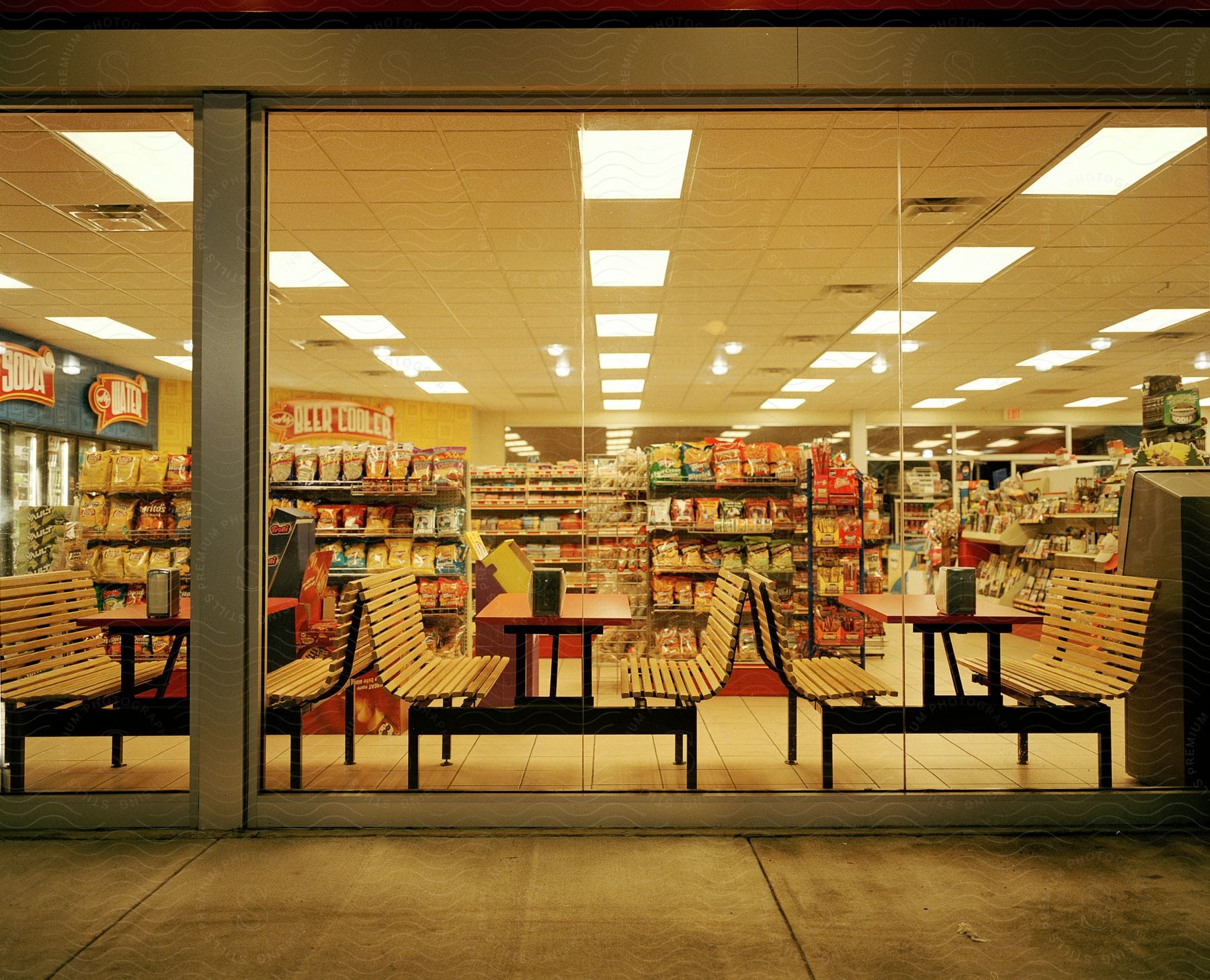 Large storefront with benches tables aisles of food and refrigerators with drinks