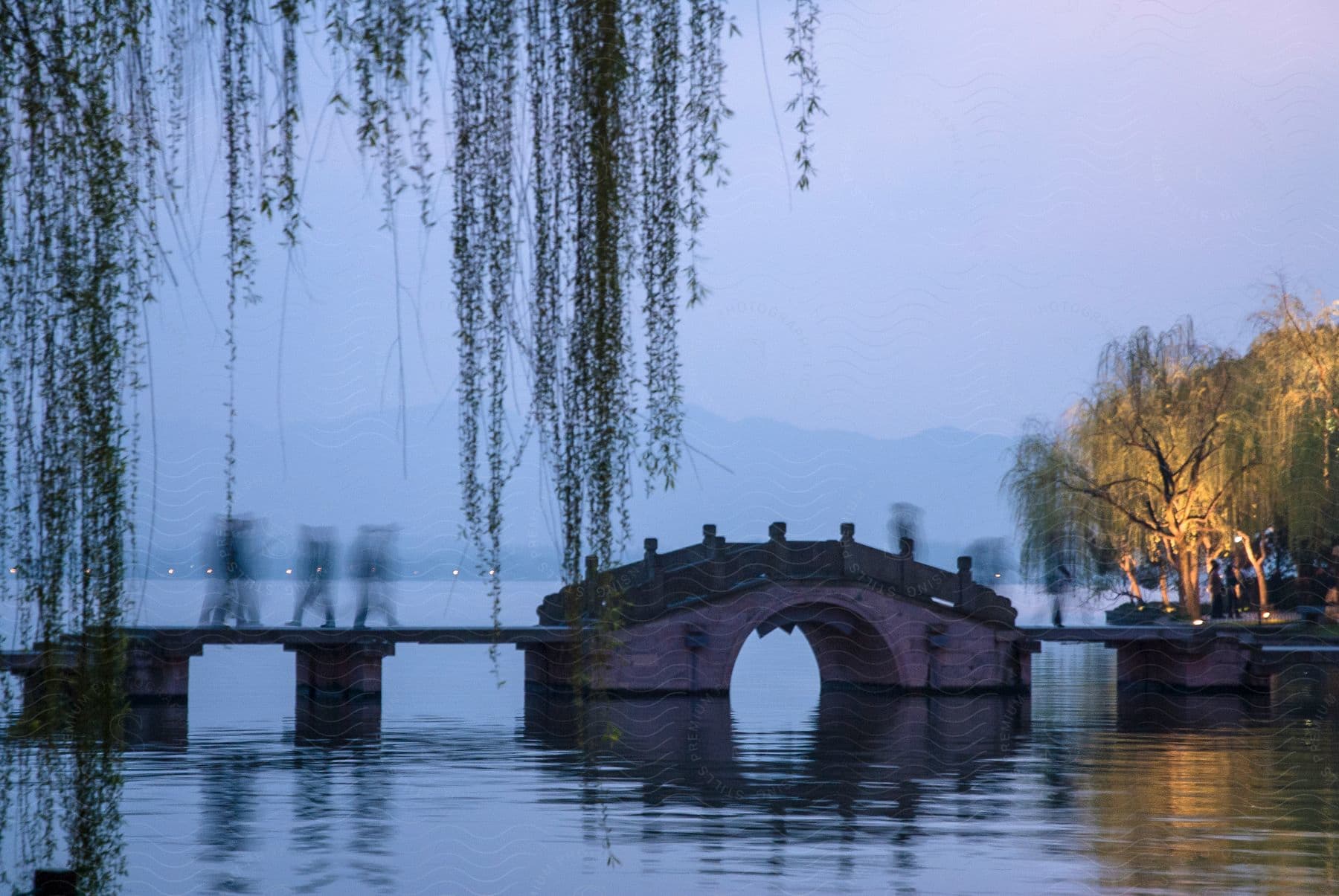 Three people walk across a bridge over the water