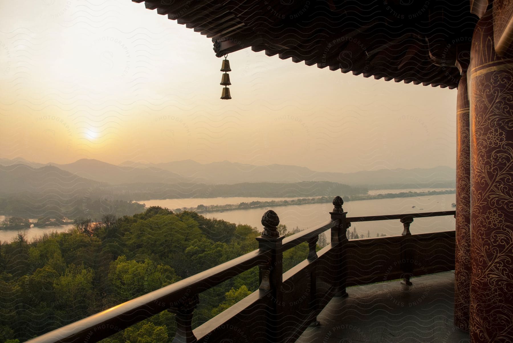 A balcony overlooks a lake and mountains in the distance