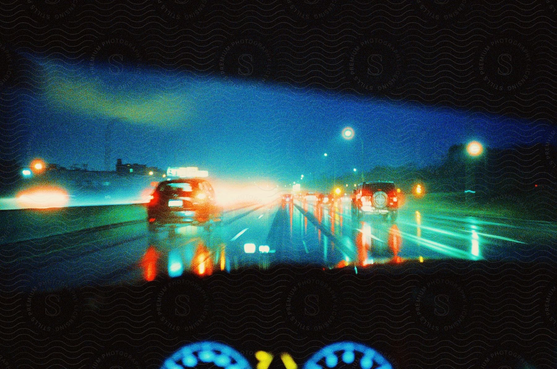 A Driver Drives Down A Slick Highway At Night With Car Lights Reflecting Off The Damp Asphalt