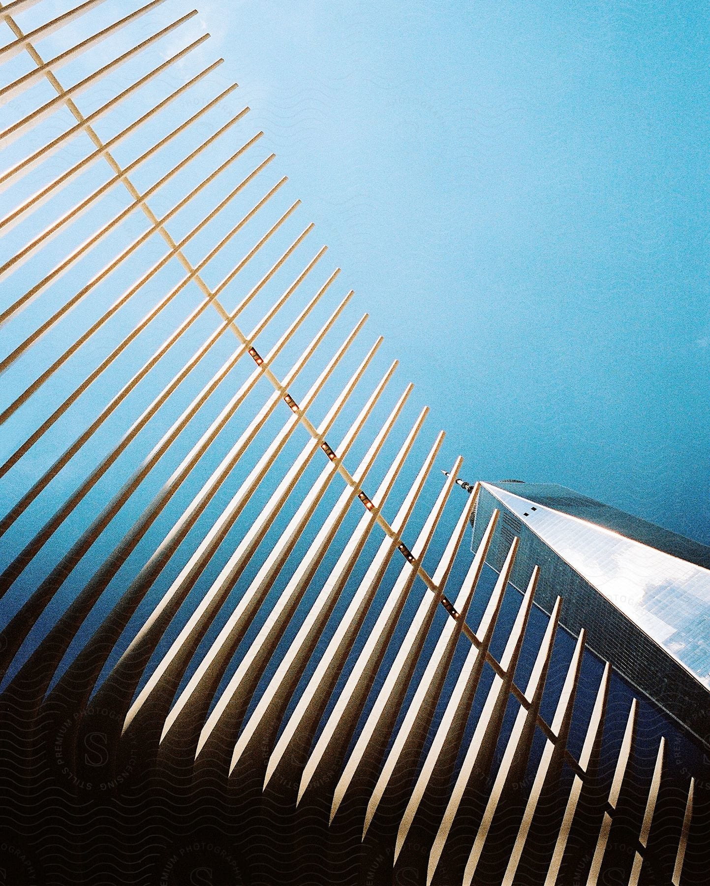 Metal fences and skyscraper with spire against the blue sky