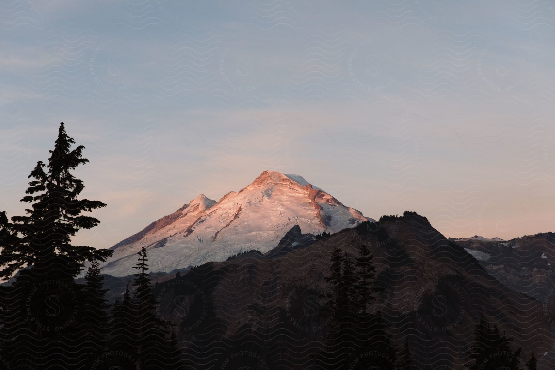 Mountain landscape at dawn with snow and vegetation