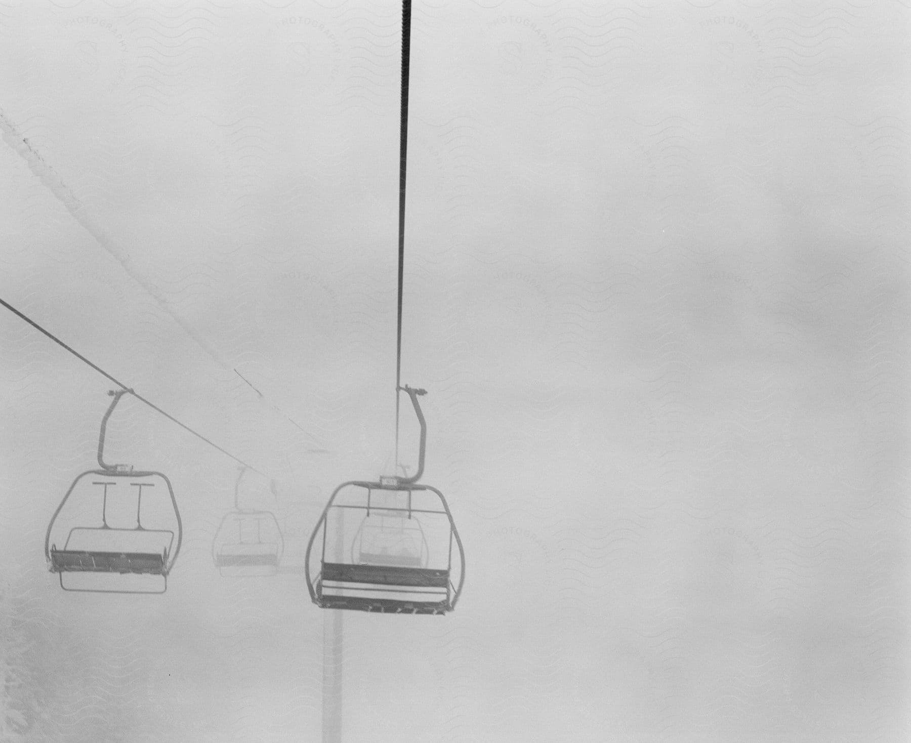 Ski lifts covered by snowy fog in black and white