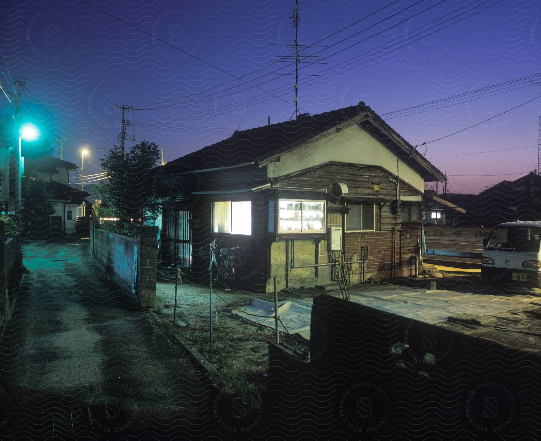 A small house with an alley on one side and a road on the other