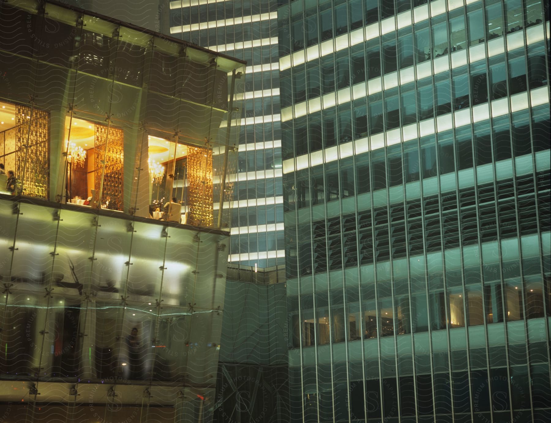 Interior lights shine through the glass exterior of a building