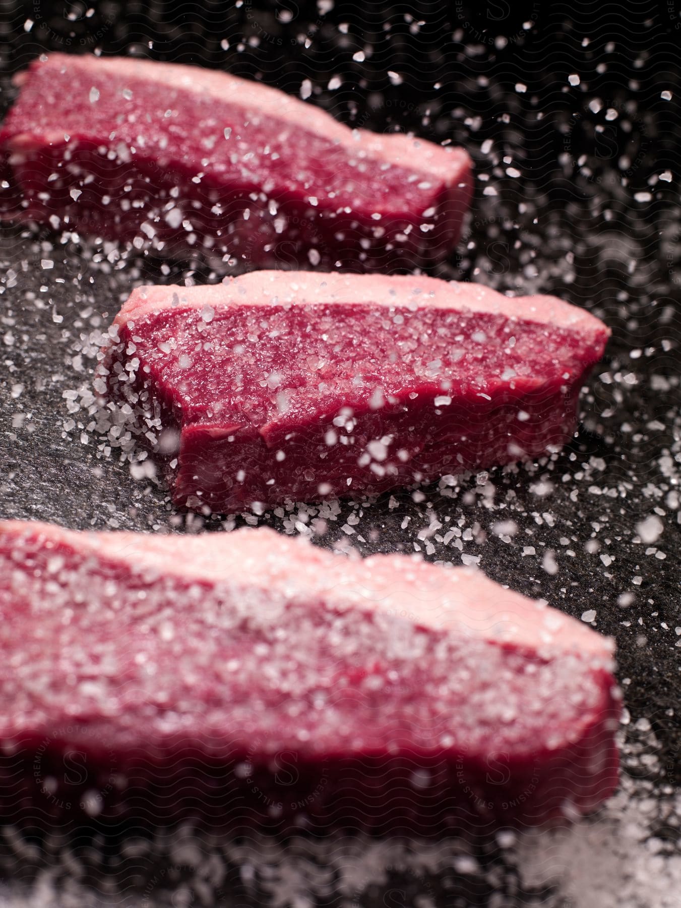 Stock photo of large pieces of meat sprinkled with coarse salt