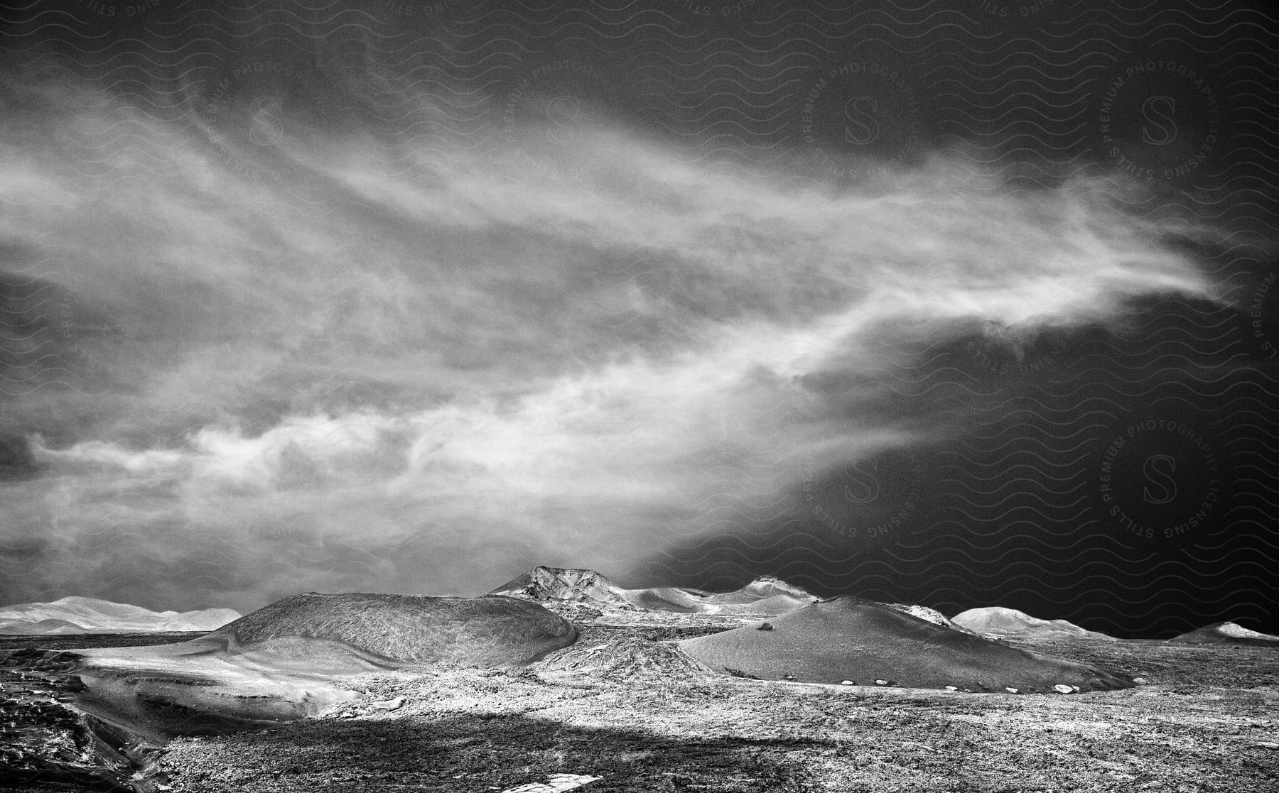 A black and white image of a sea and a cloudy sky