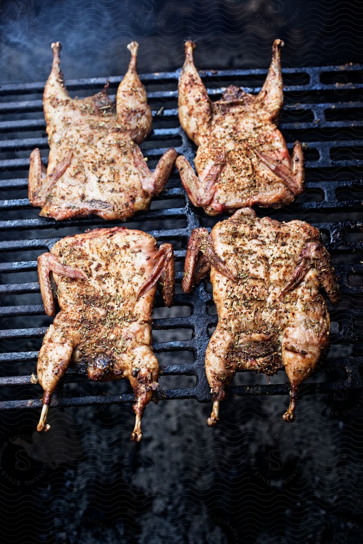 Seasoned chickens arranged on a grill