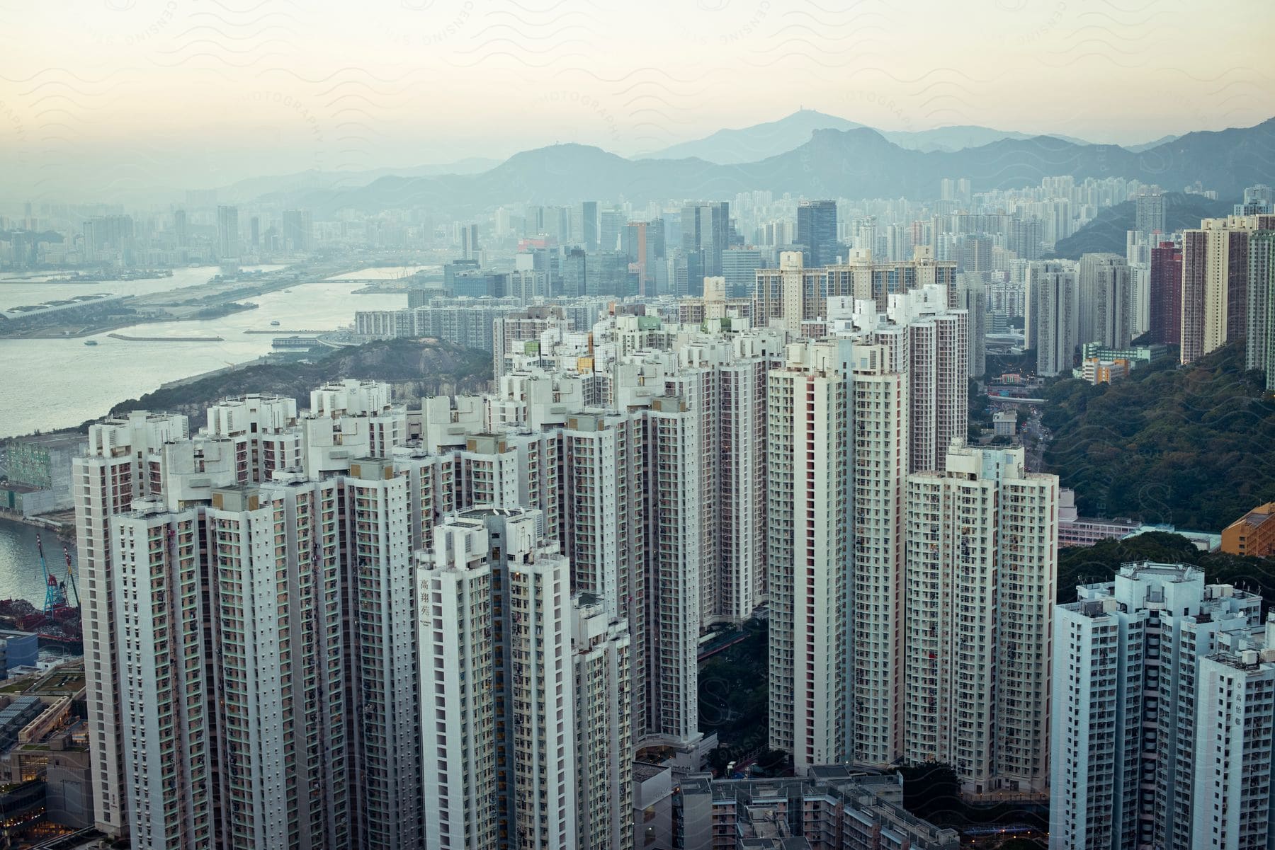 Aerial view of a waterfront city skyline with mountains in the background