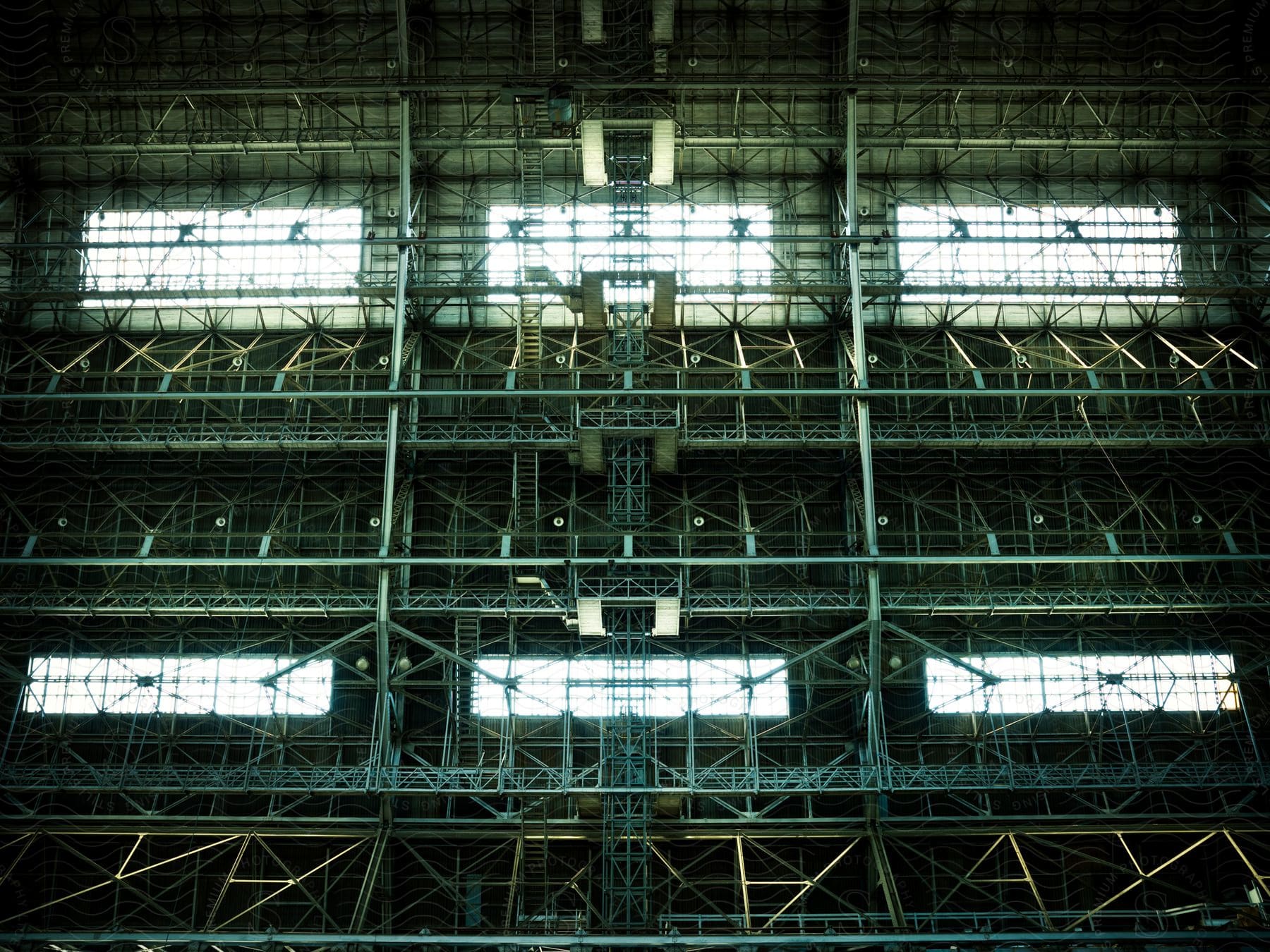 Scaffolding covers a wall allowing light from windows to shine into a large structure