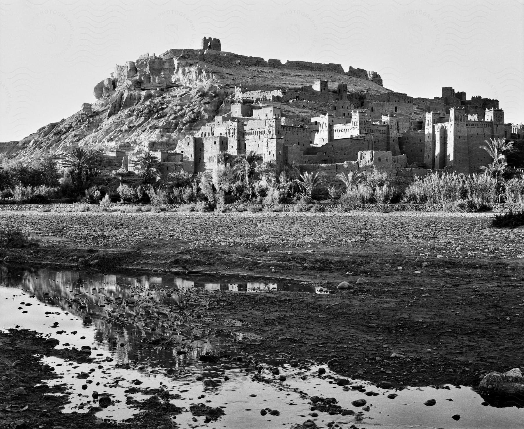 Stock photo of a fortified town is situated on a hill slope near a field with a river