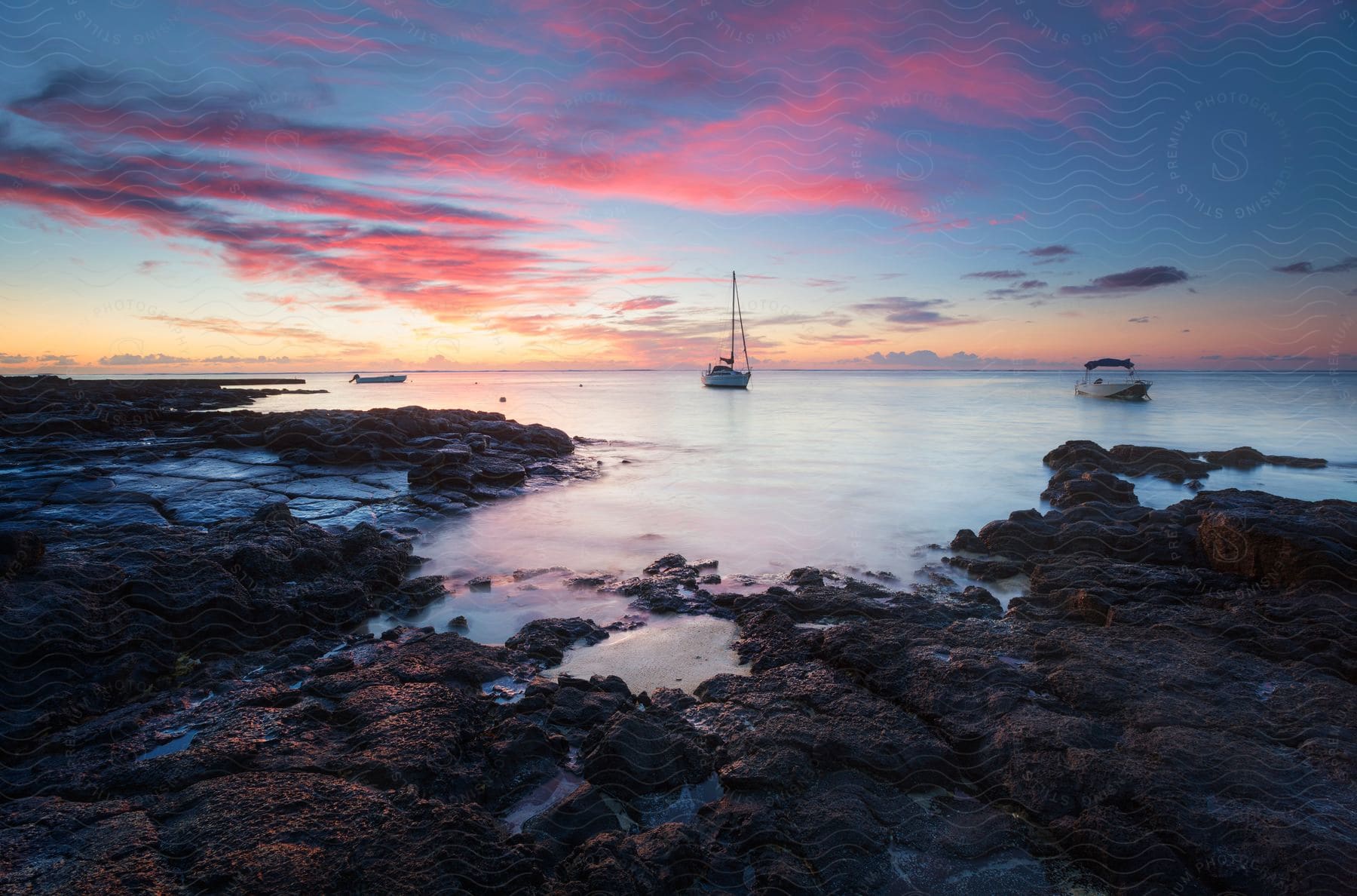 Coastline with a boat visible at a distance during sunrise at bluebay on mauritius