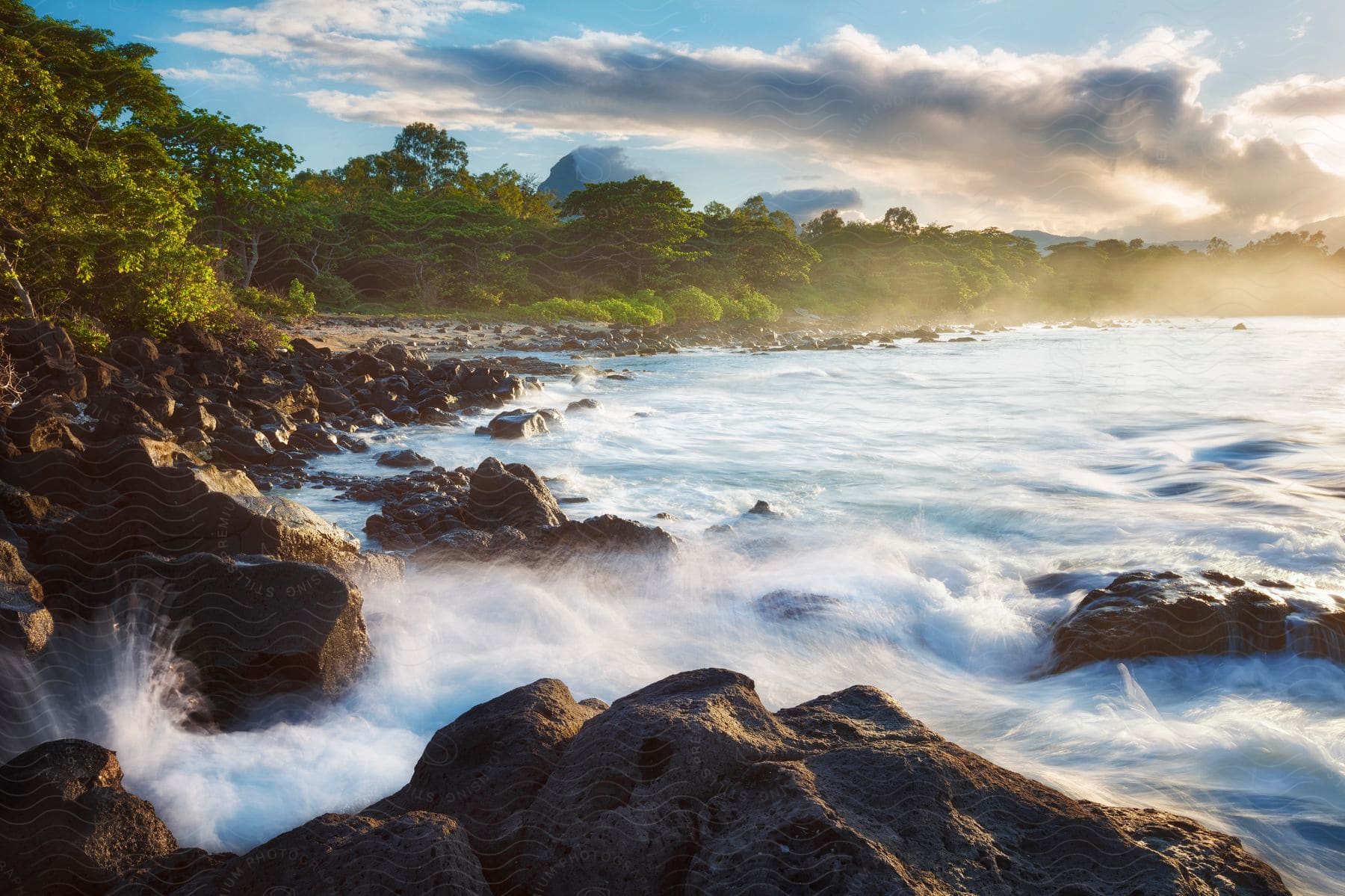 Ocean waves moving towards rocks at dusk on the wild coast of mauritius near wolmar beach with a view towards mount du rempart