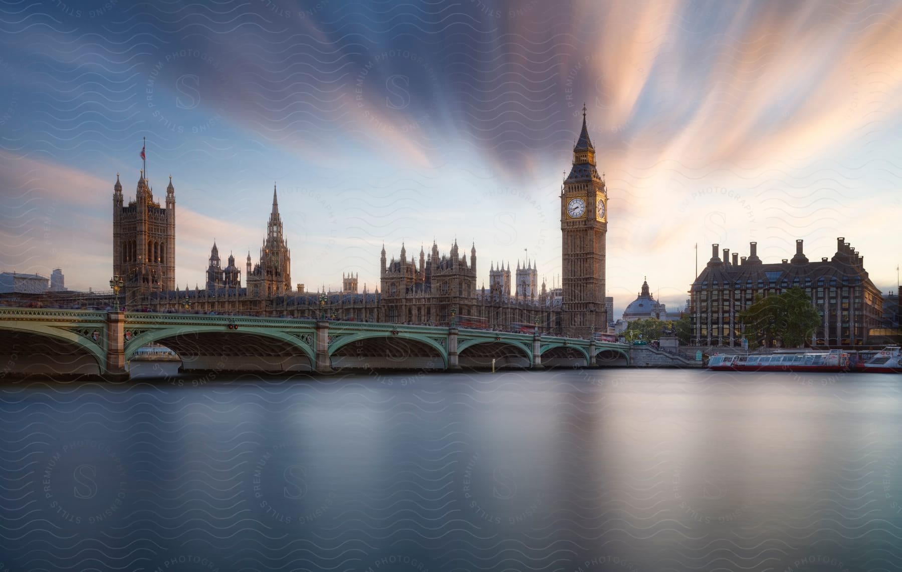 A Sunset View Of Big Ben The Houses Of Parliament And Westminster Bridge With A Boat On The River Thames In The Foreground