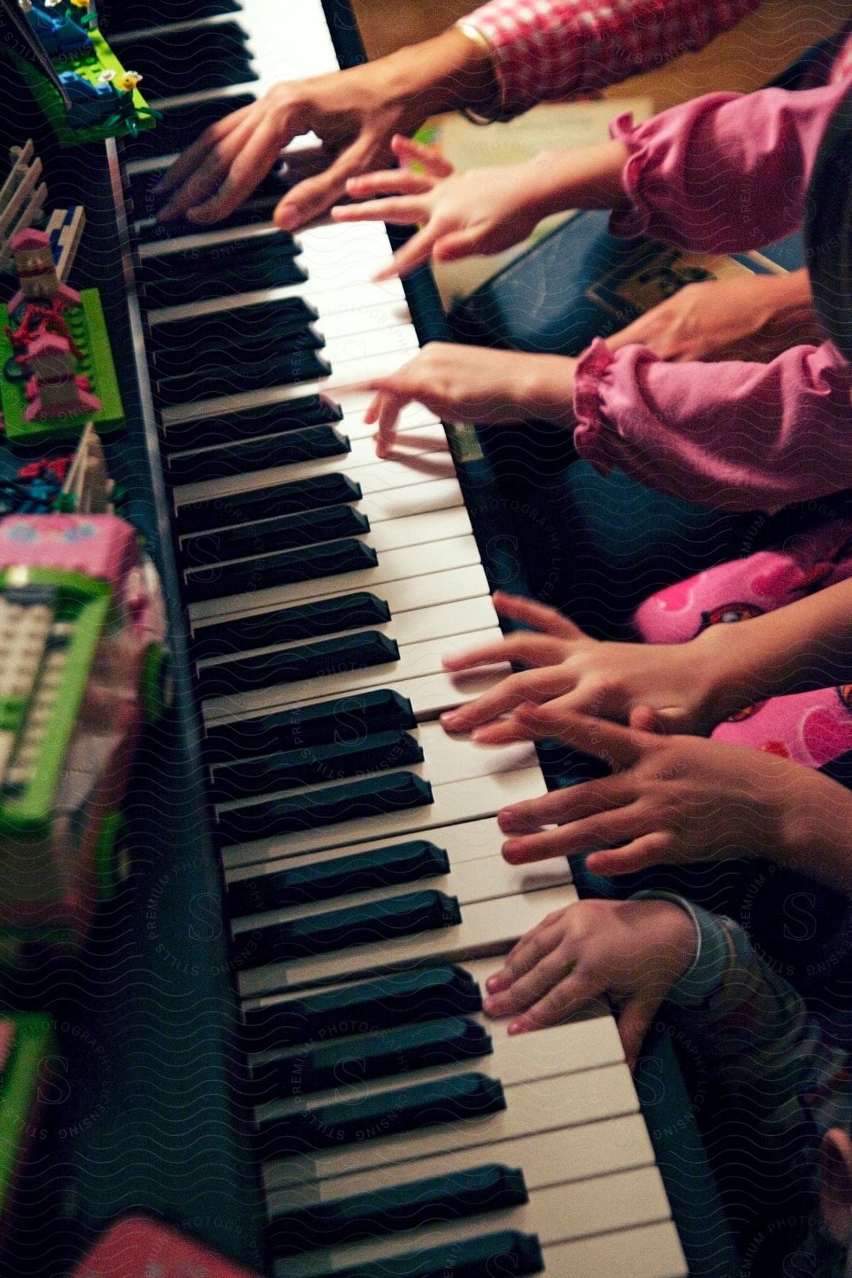 A group of people playing a piano together