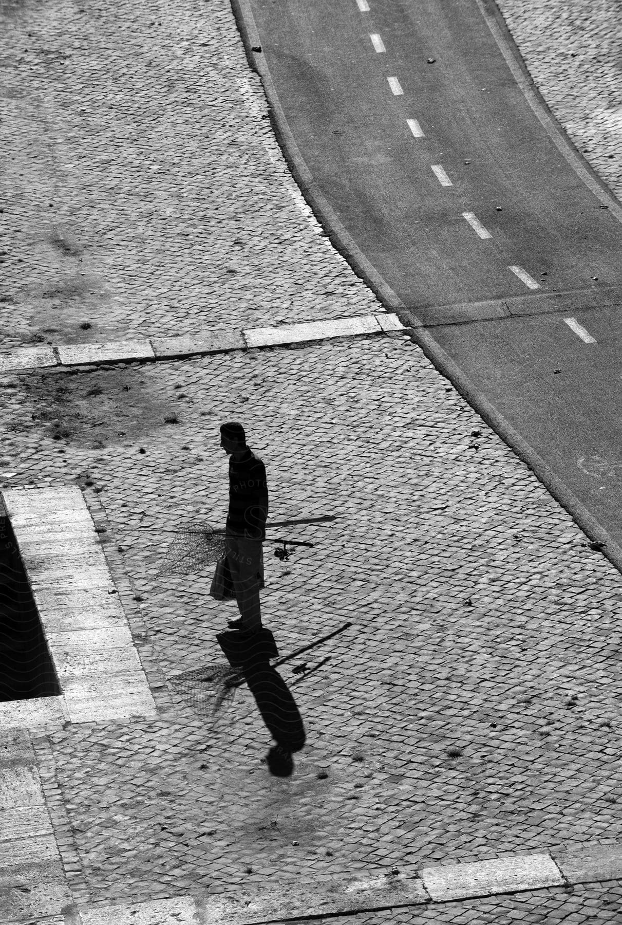 A middleaged man walking alone on a grey road