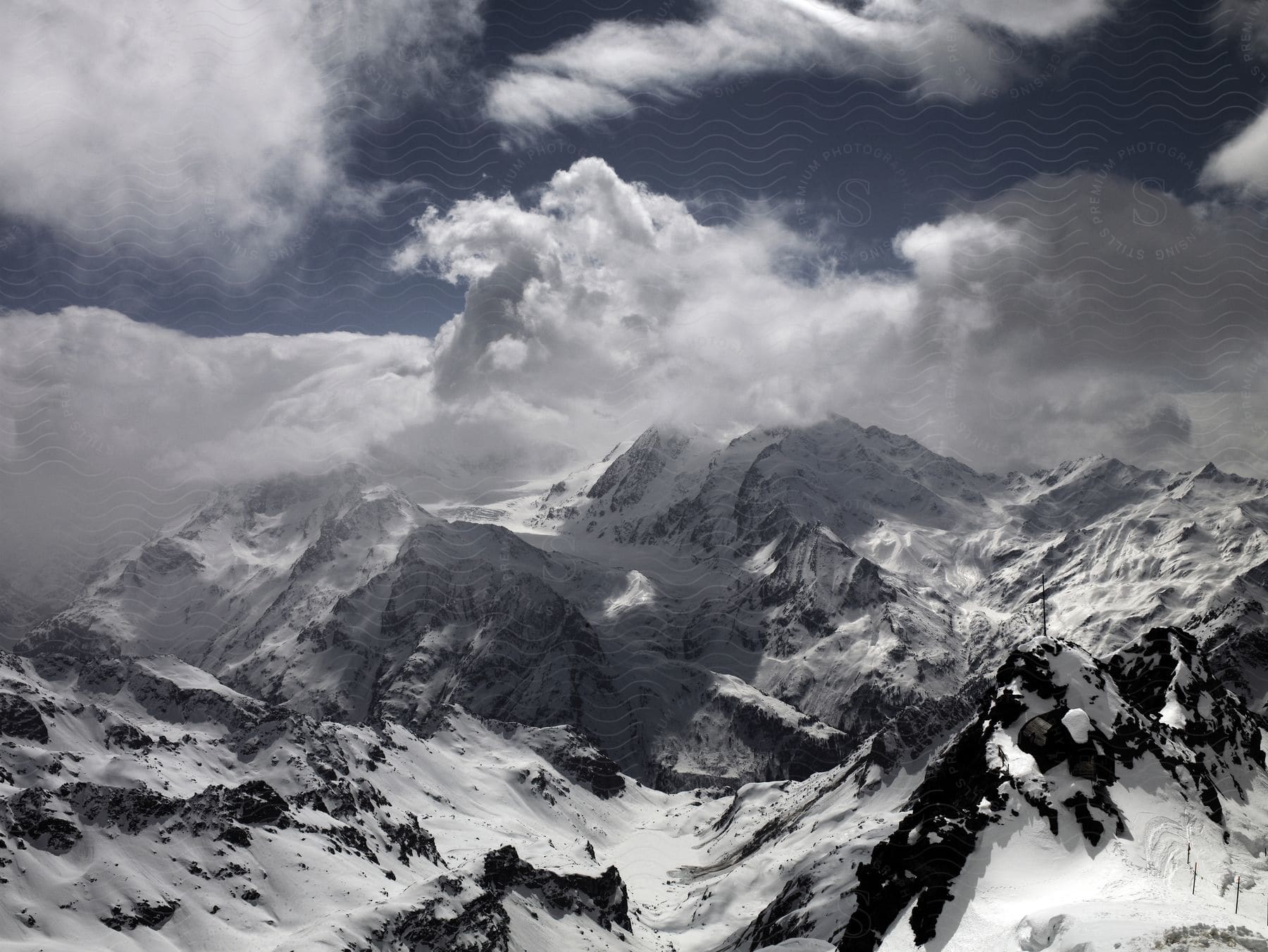 Snowy mountains under cloudy skies viewed from the air