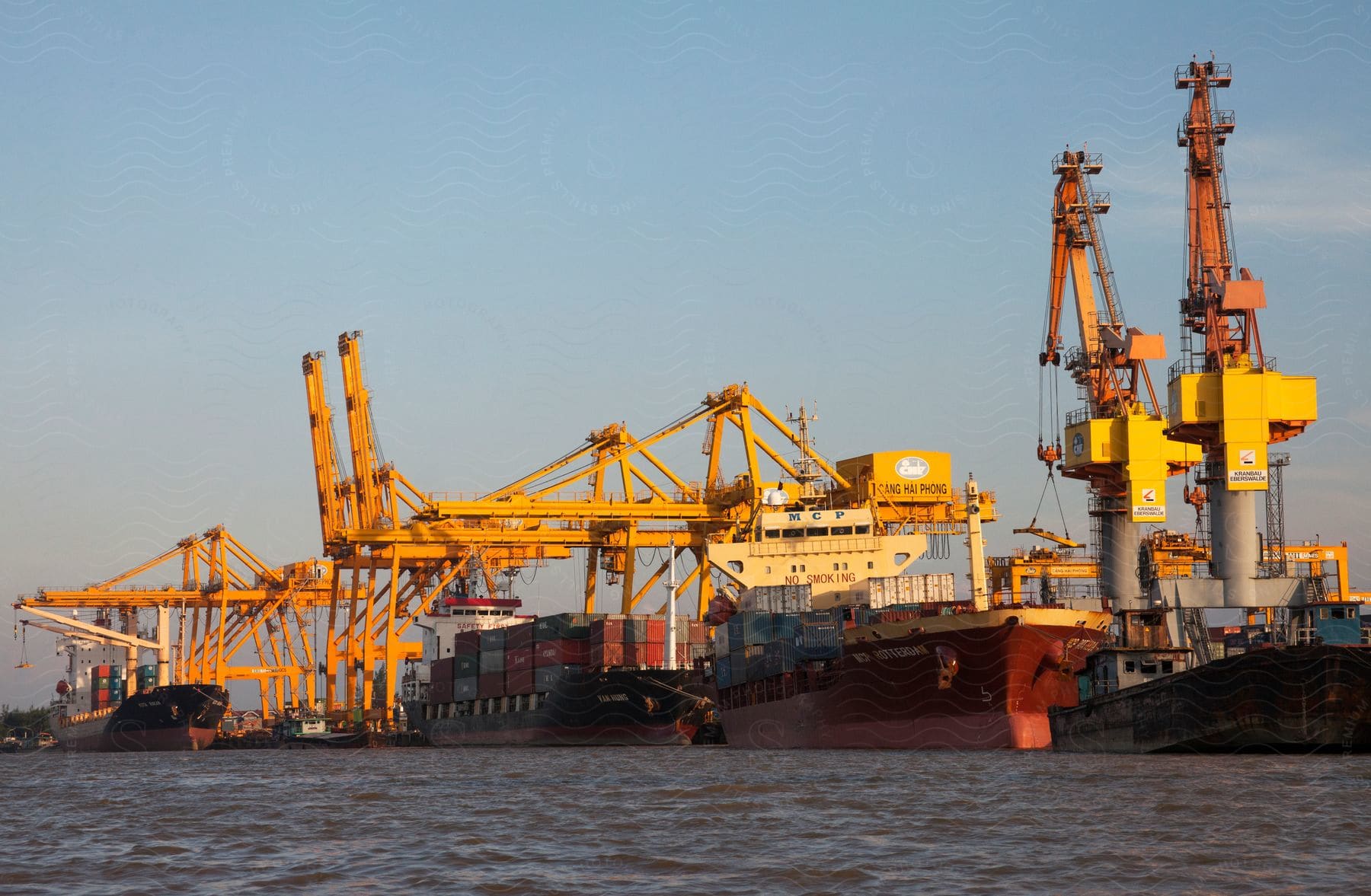 Several cargo ships are docked at a port waiting for the loading and unloading of goods