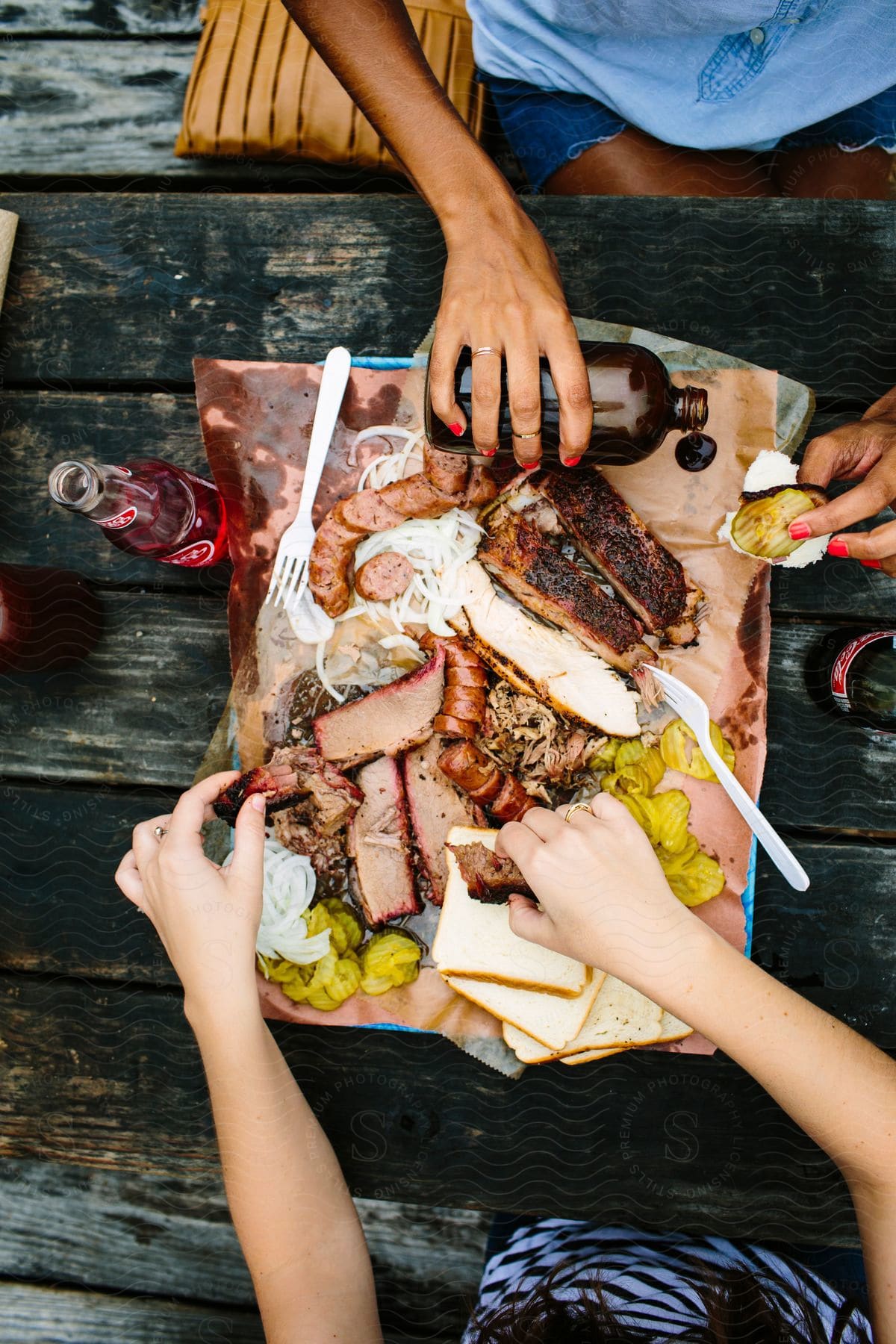 Two people sharing a plate of different bbq foods