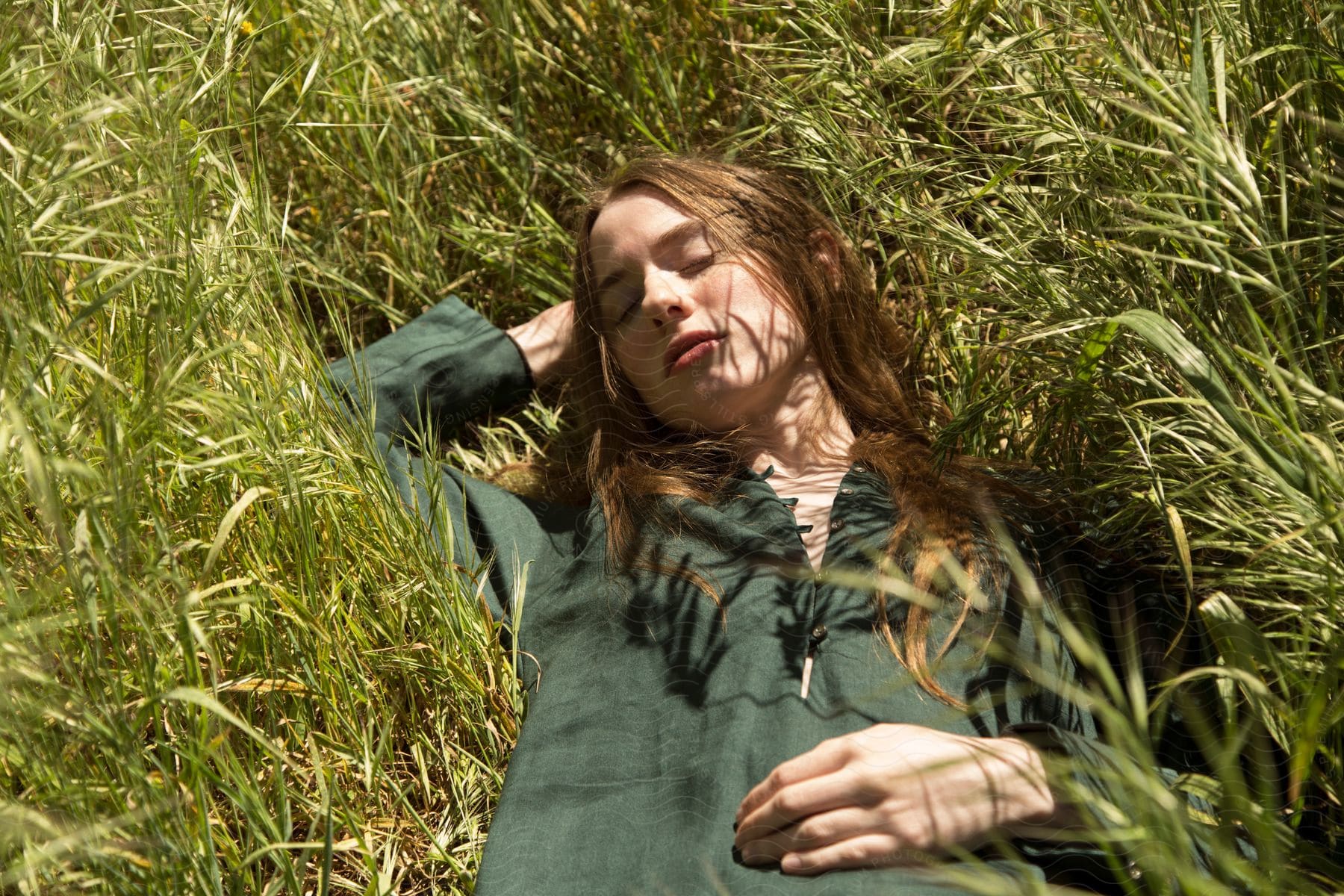A teenage girl relaxes on the grass in a light jacket